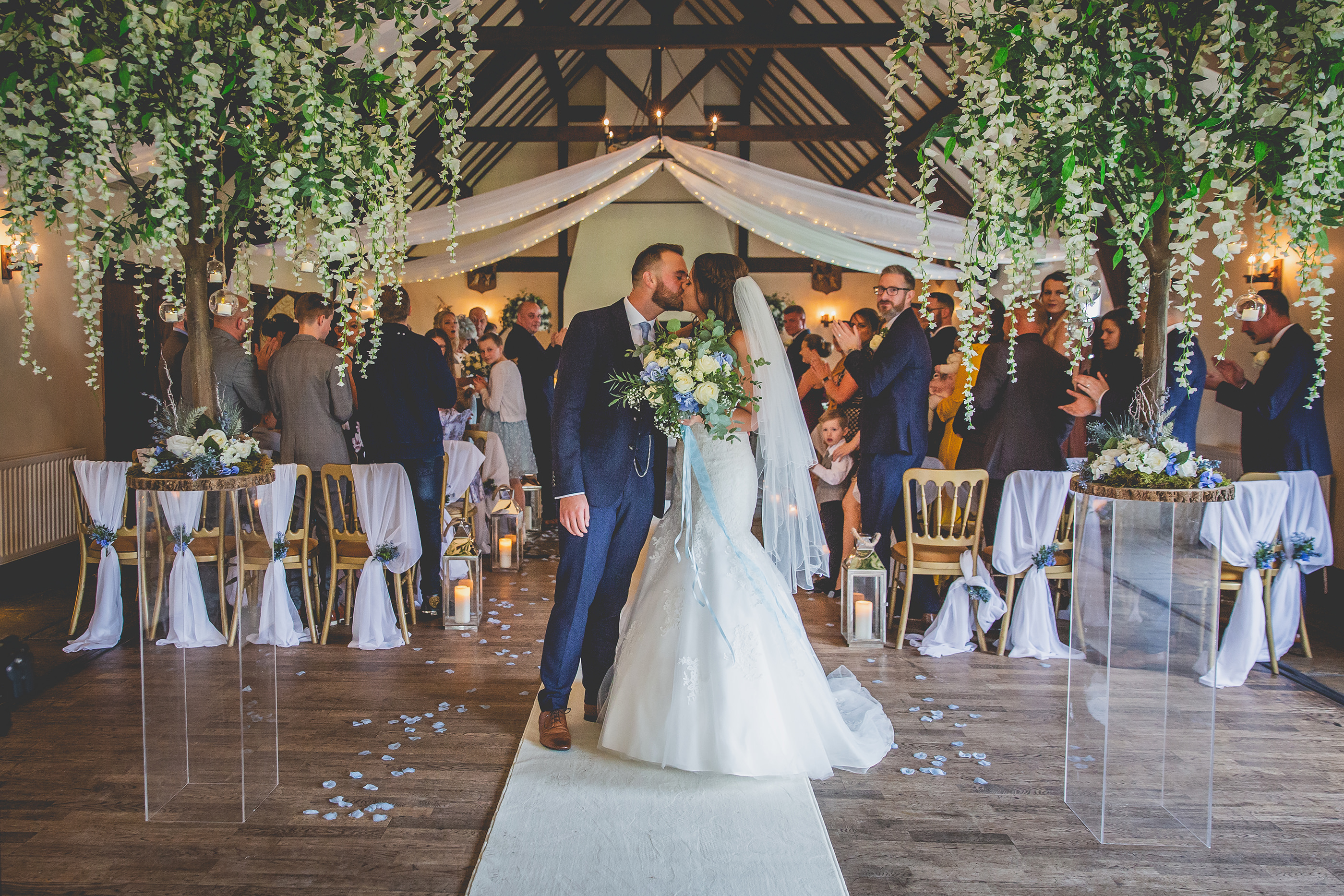 the bride and groom walk down the aisle at Mains Hall