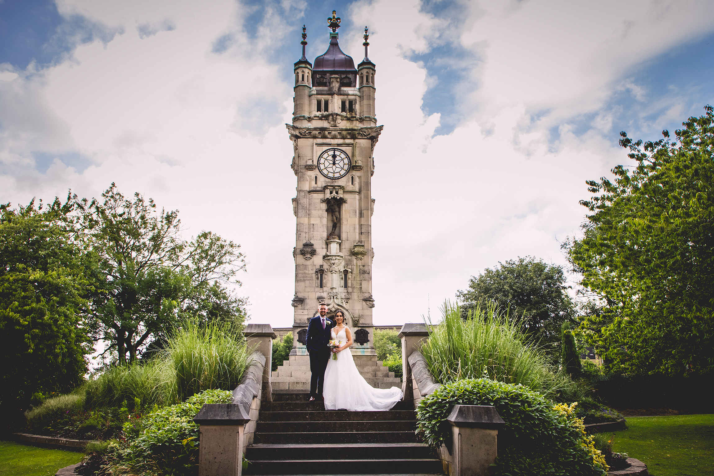 the bride and groom wedding photo in front of the clock tower in Bury