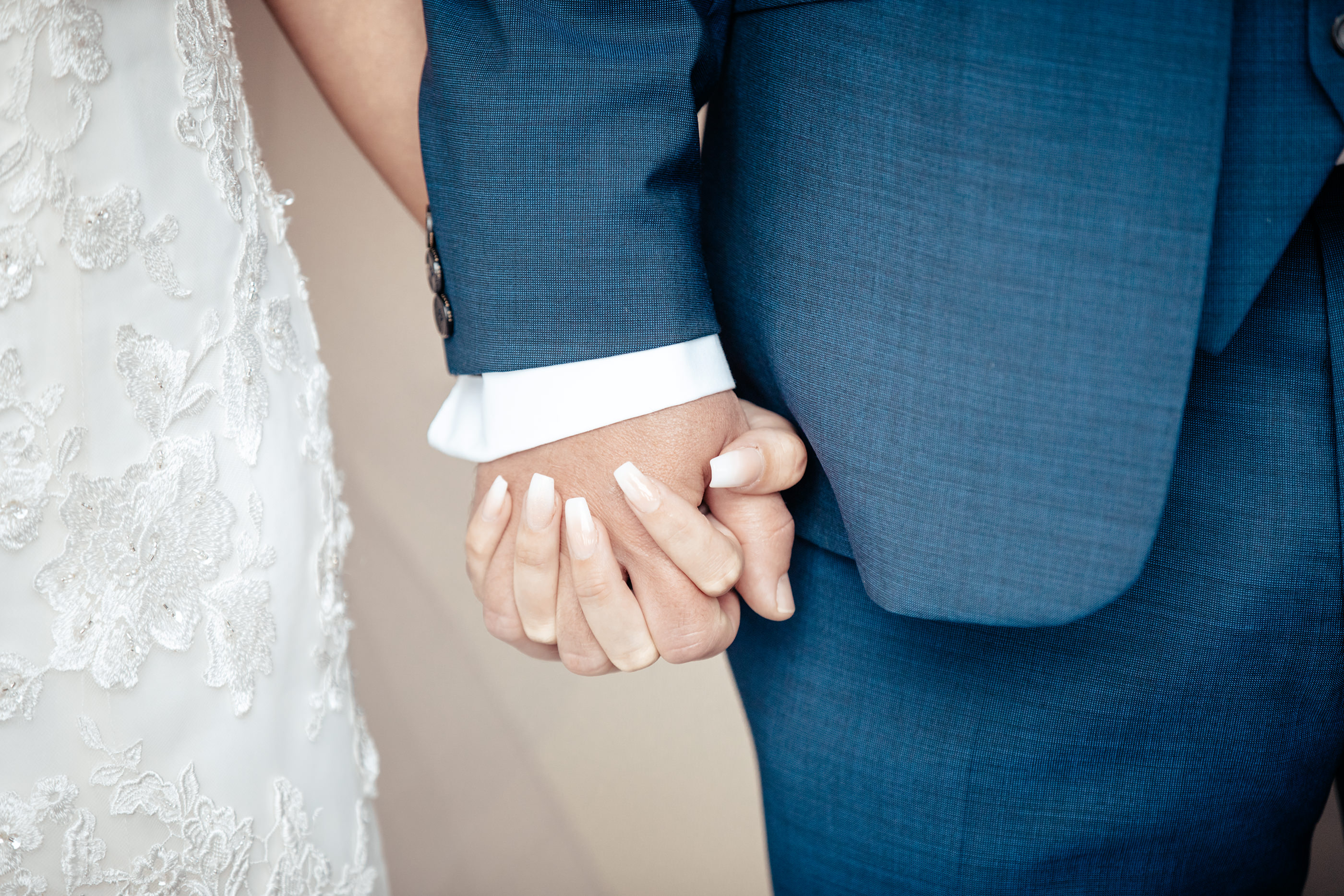 The bride and groom hold hands 