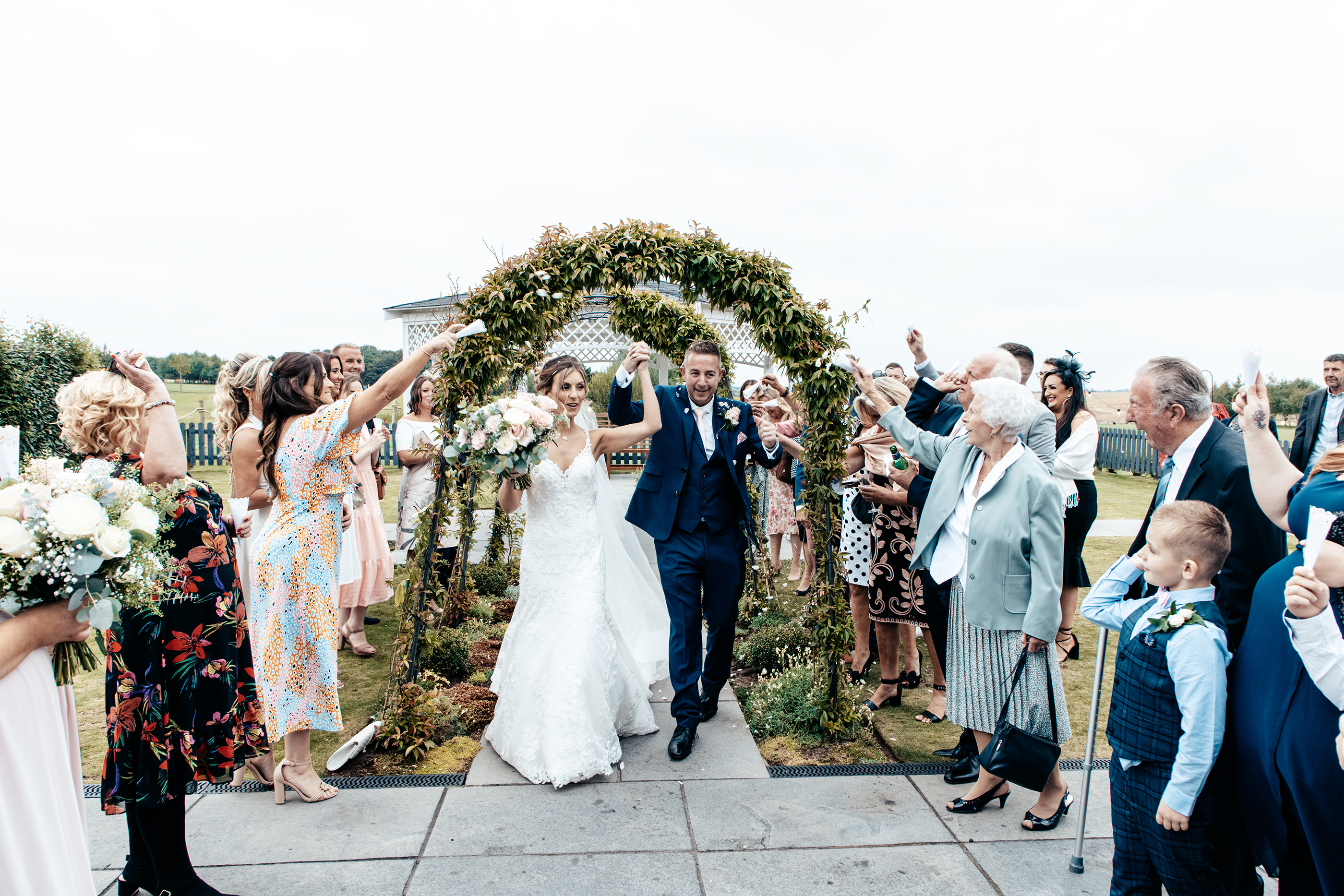 The guests throw confetti at the bride and groom 