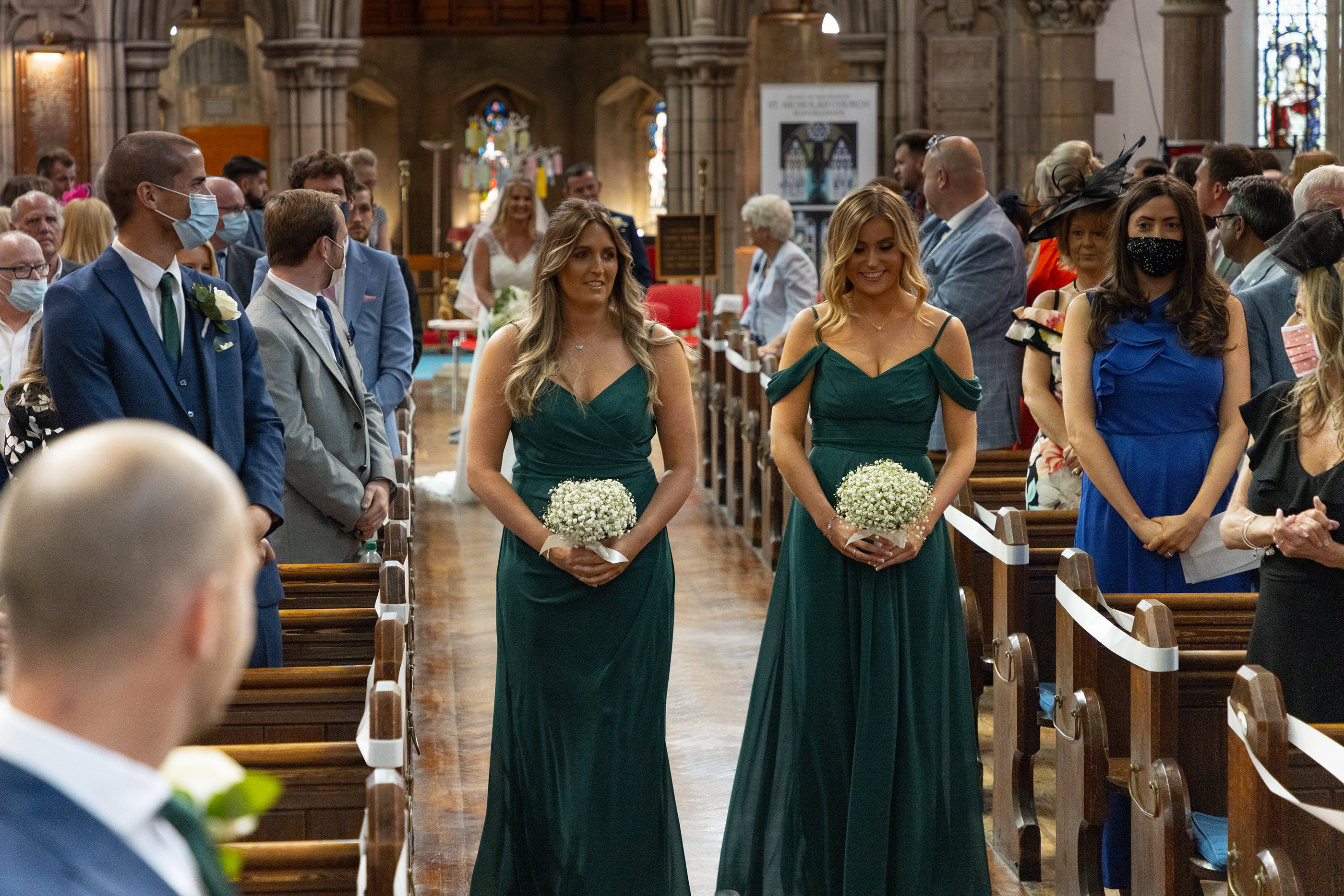 the bridesmaids walk up the church isle 