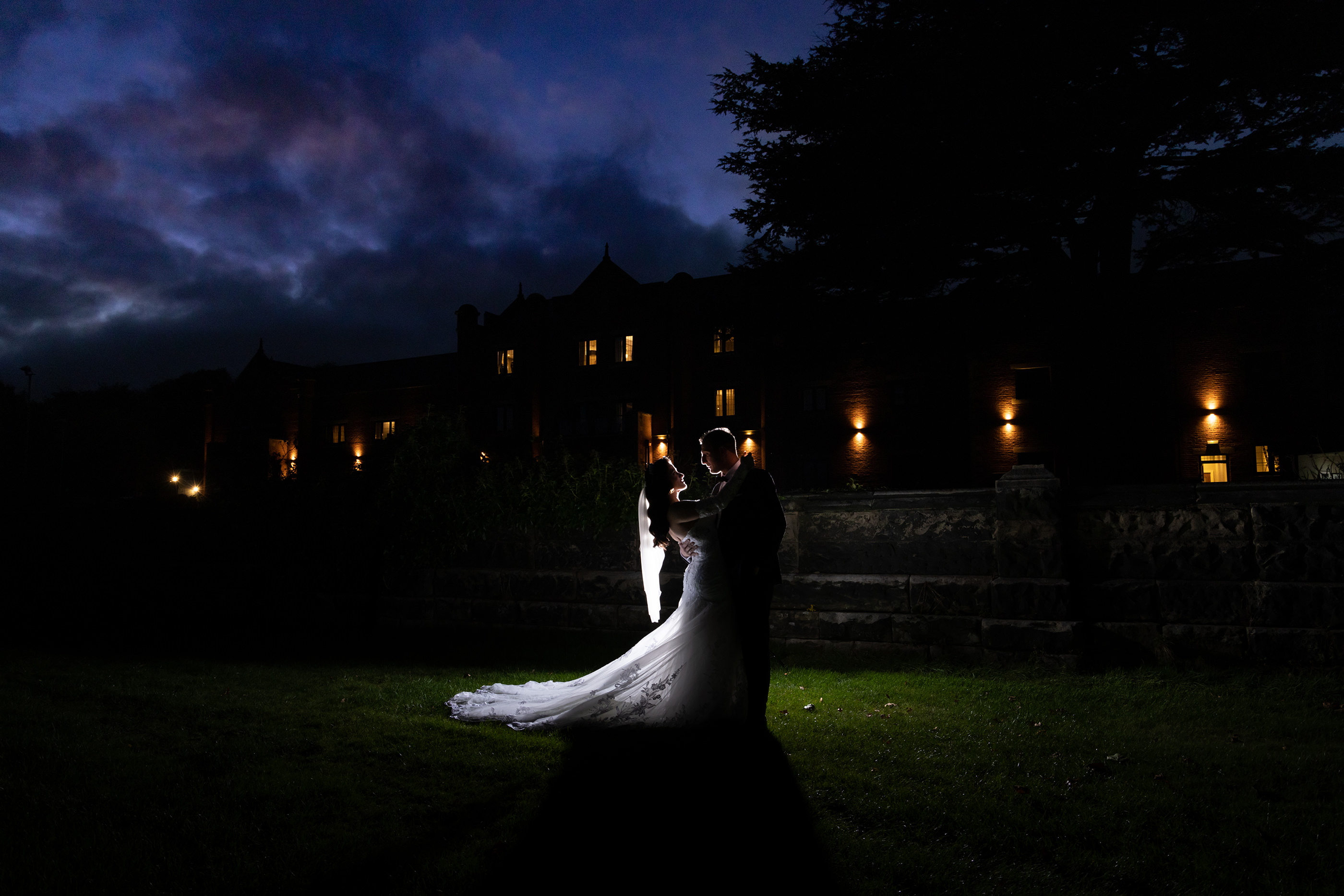  the bride and groom silhouette against the wedding hotel