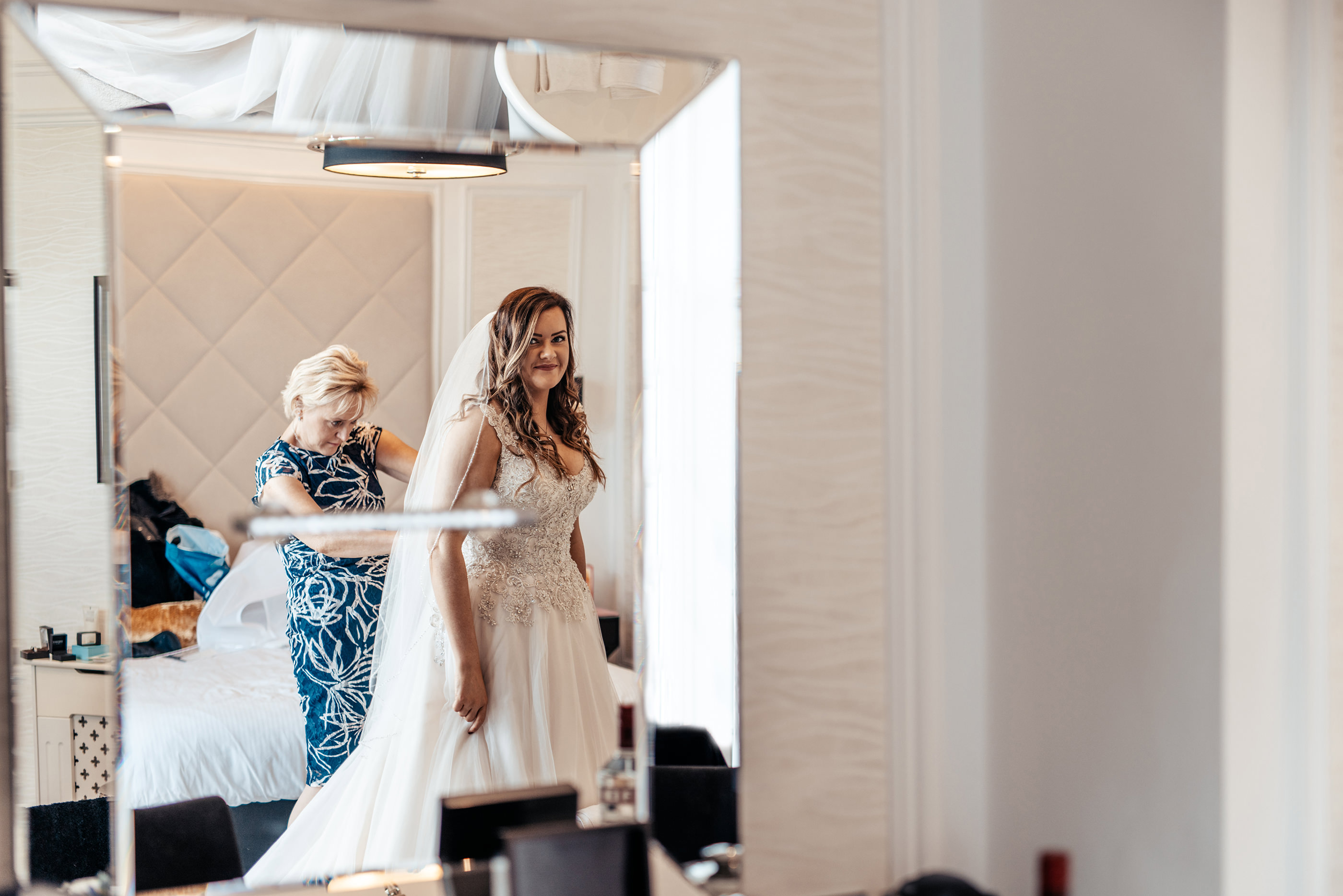  mother of the bride fastening off the wedding dress