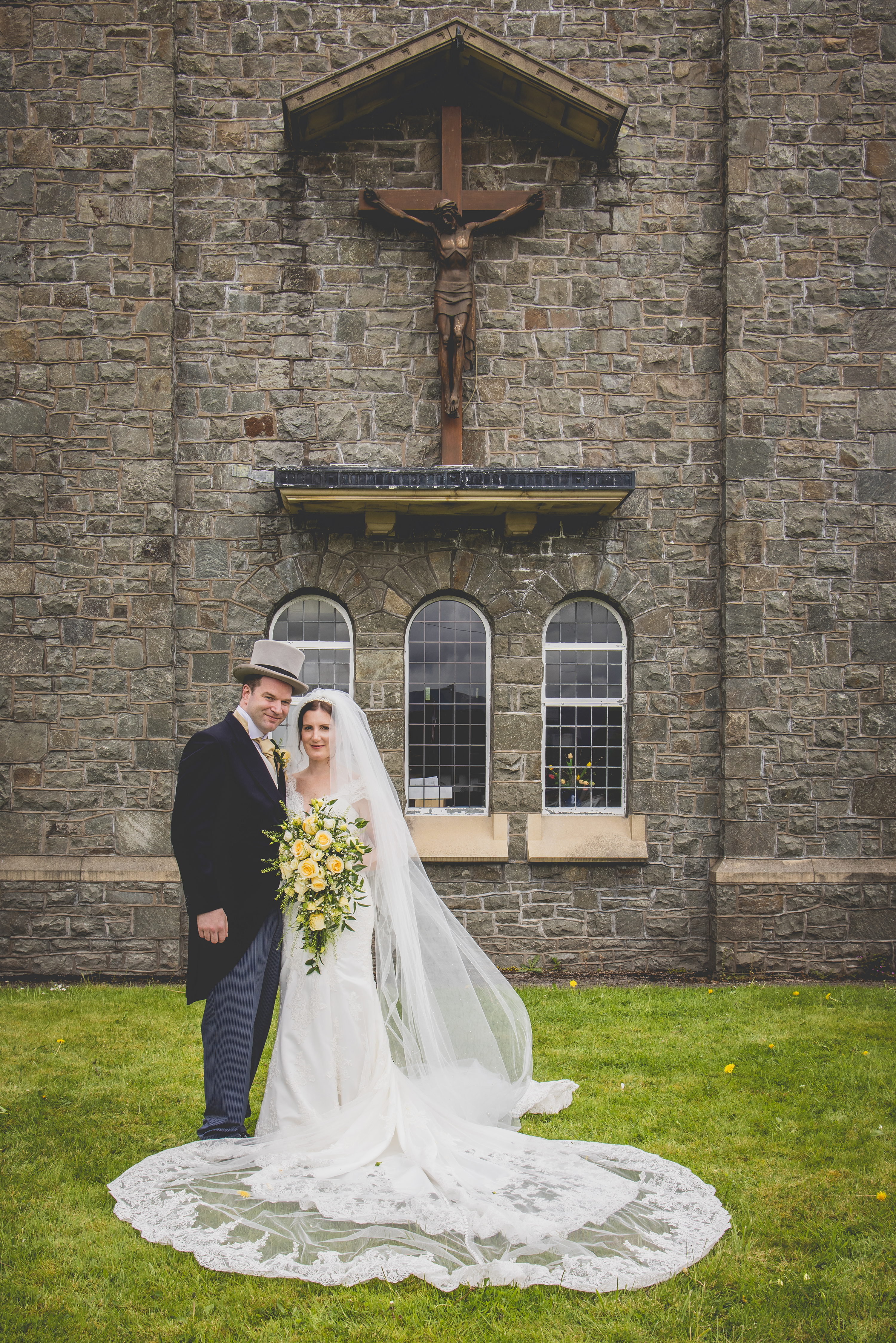 The bride and groom pose for a photo at Our Lady of the lakes and Saint Charles Catholic Church