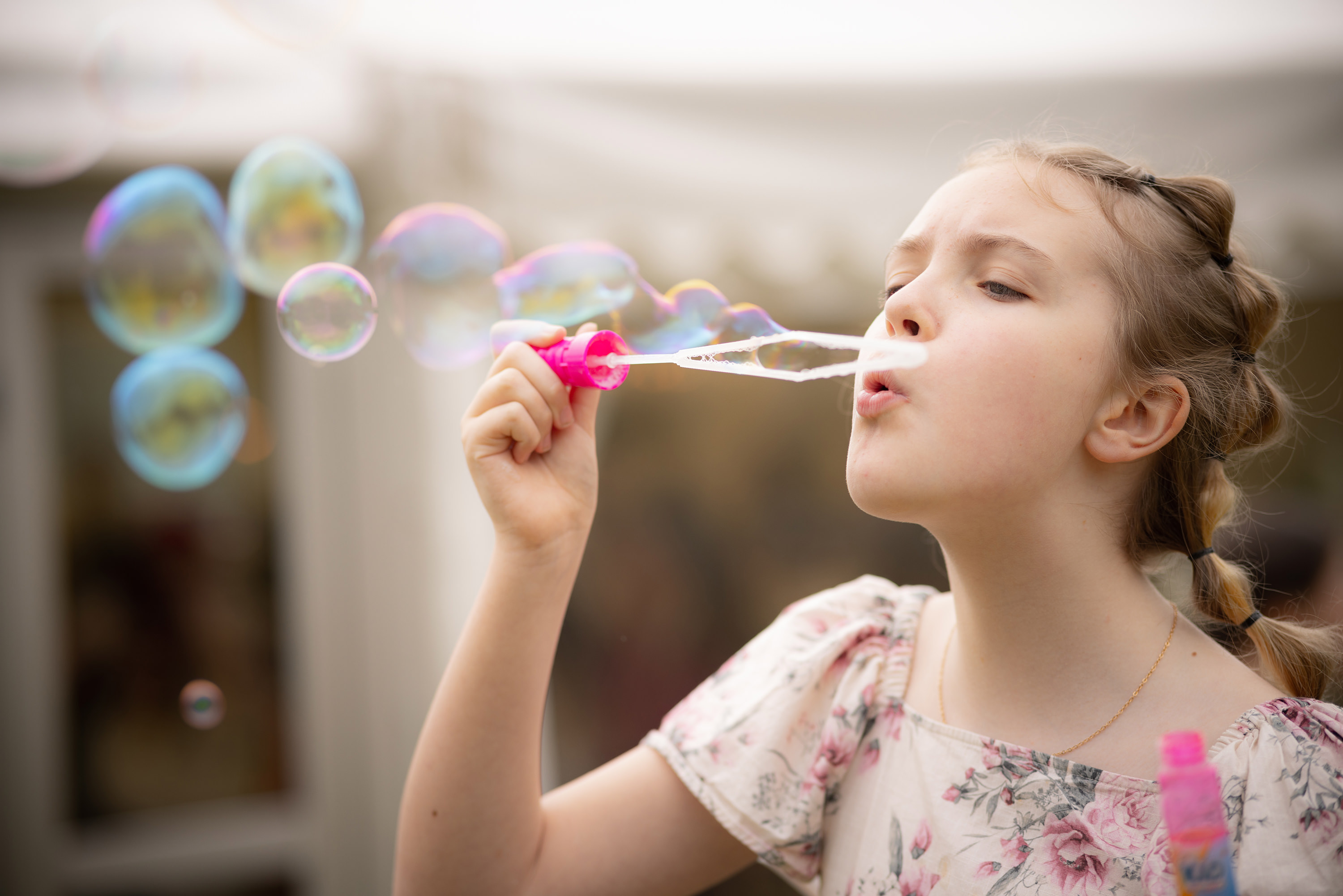 A young girl blowing bubbles at the wedding 