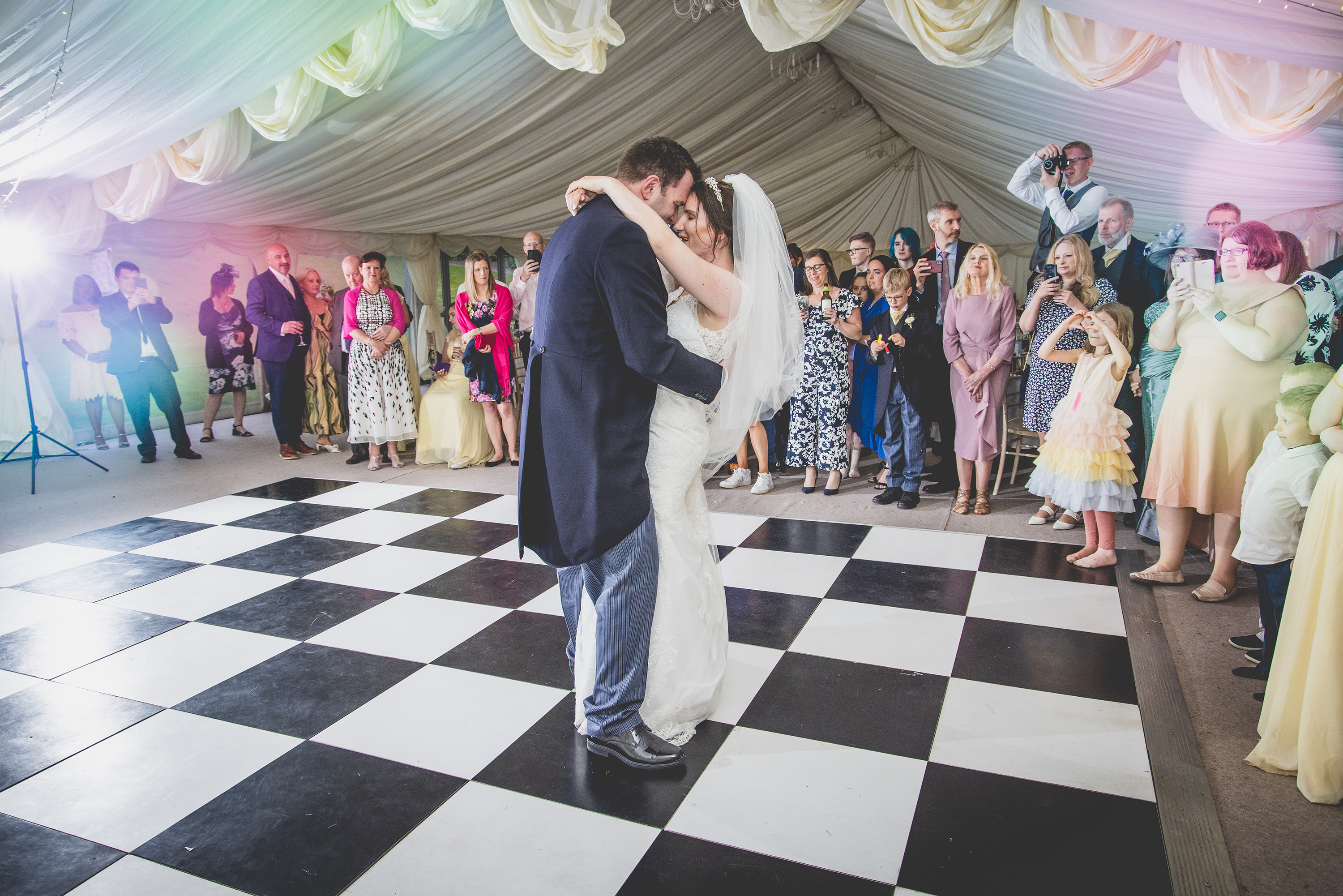 The wedding guests looking on as the couple have their first dance 