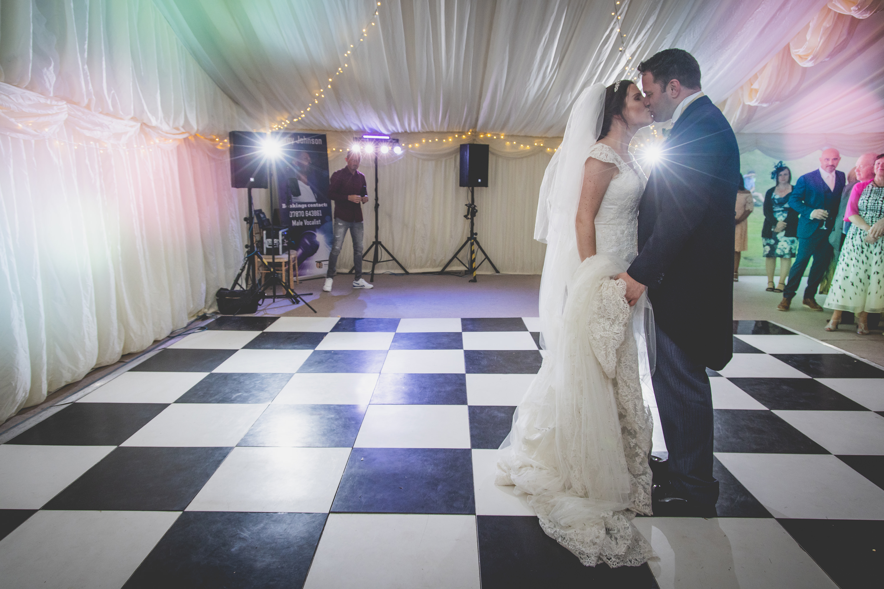 The bride and groom kiss on the dance floor 