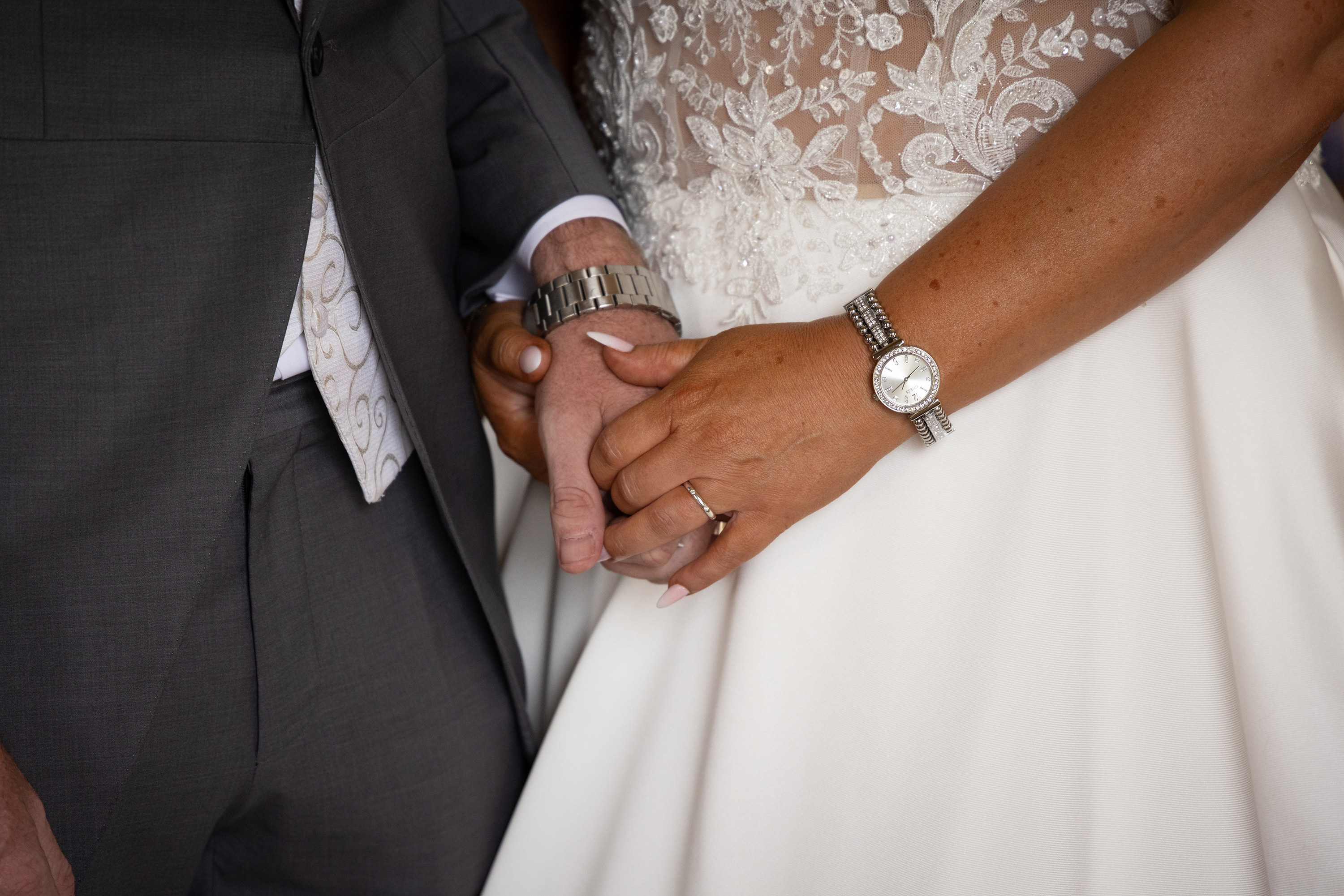 The bride and groom hold each other's hands 