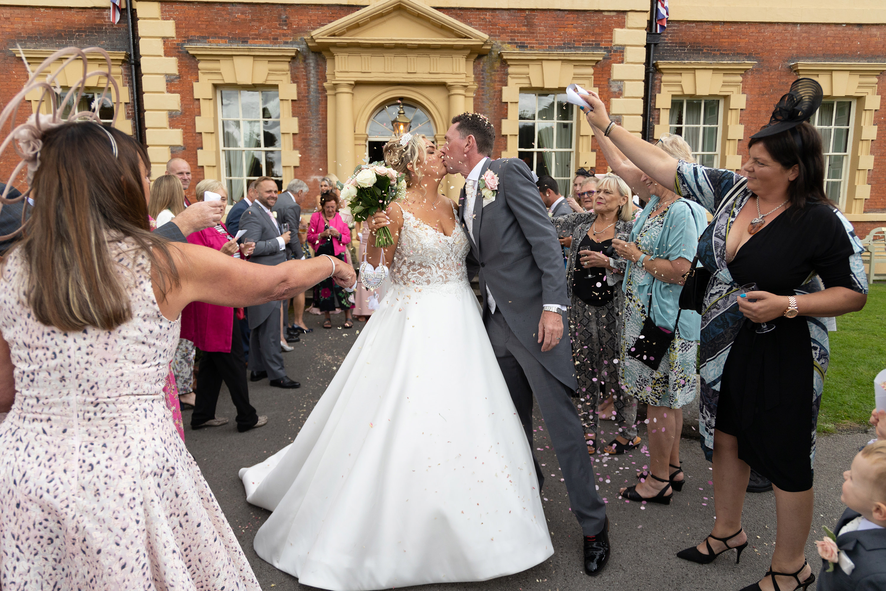 Wedding guests throw confetti at the bride and groom 