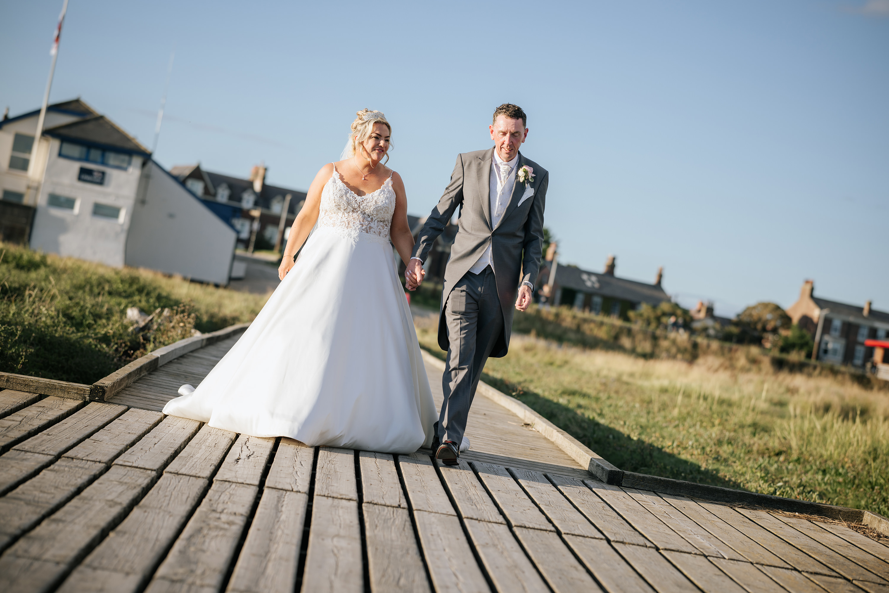 The couple walk hand in hand down Lytham jetty 