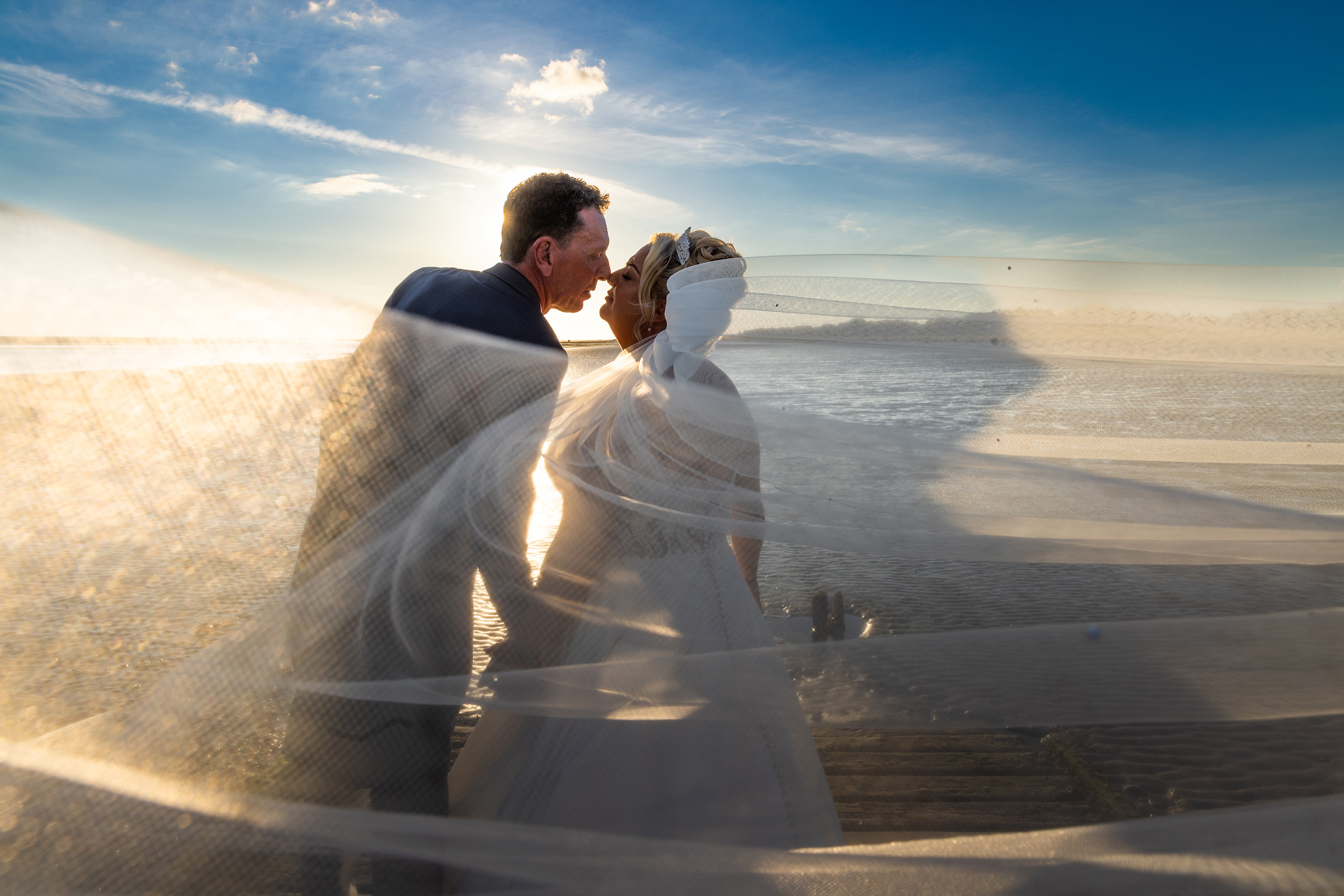 Sunset wedding with veil blowing in the wind