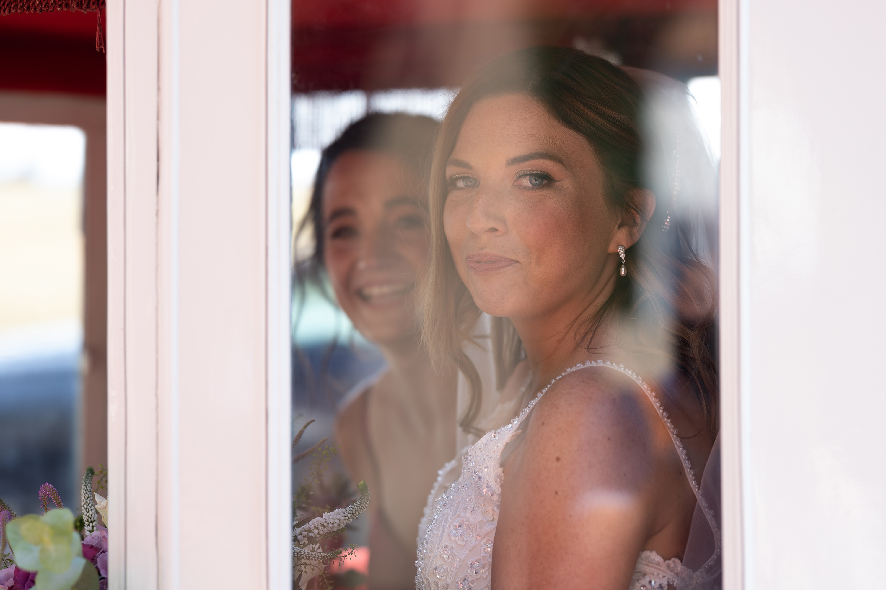 Beverly and her bridesmaids smile out the window 