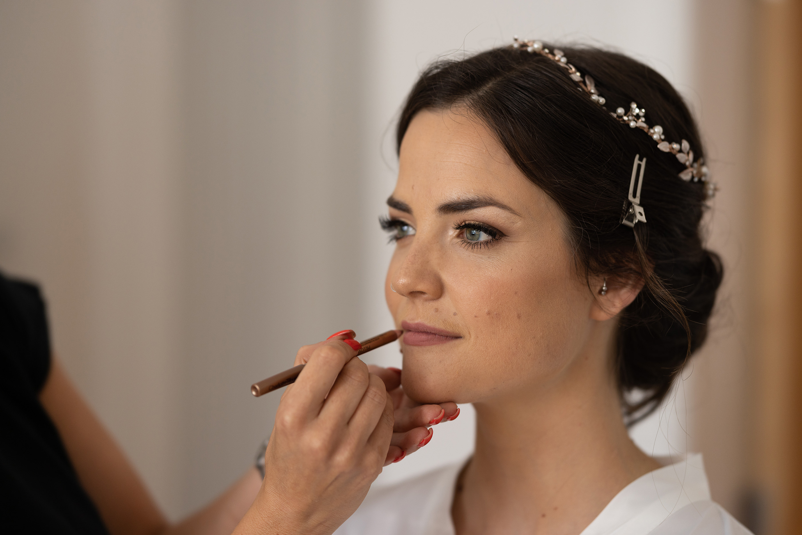 The makeup artist putting on the brides makeup