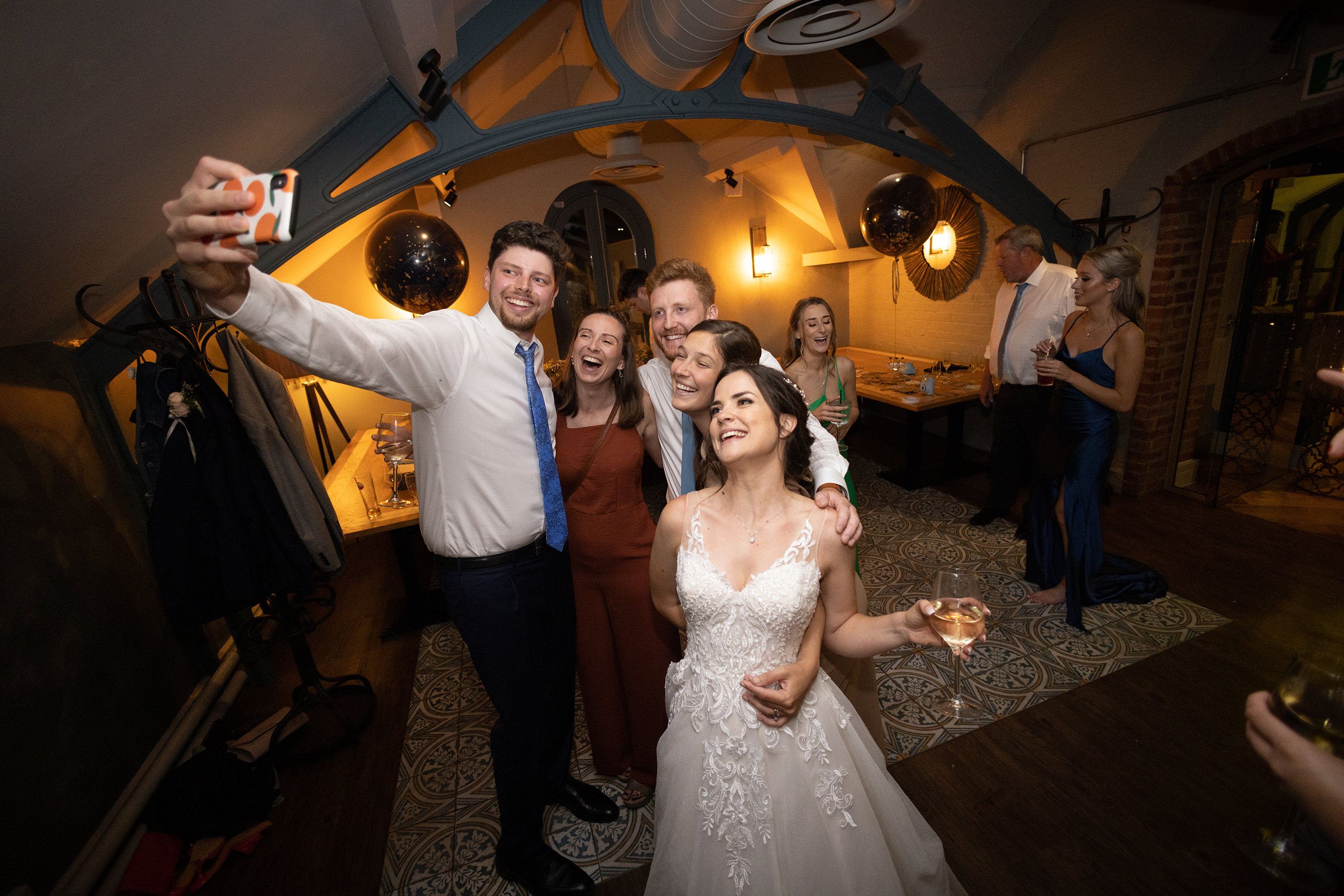 The groom takes a selfie with his wife and friends 