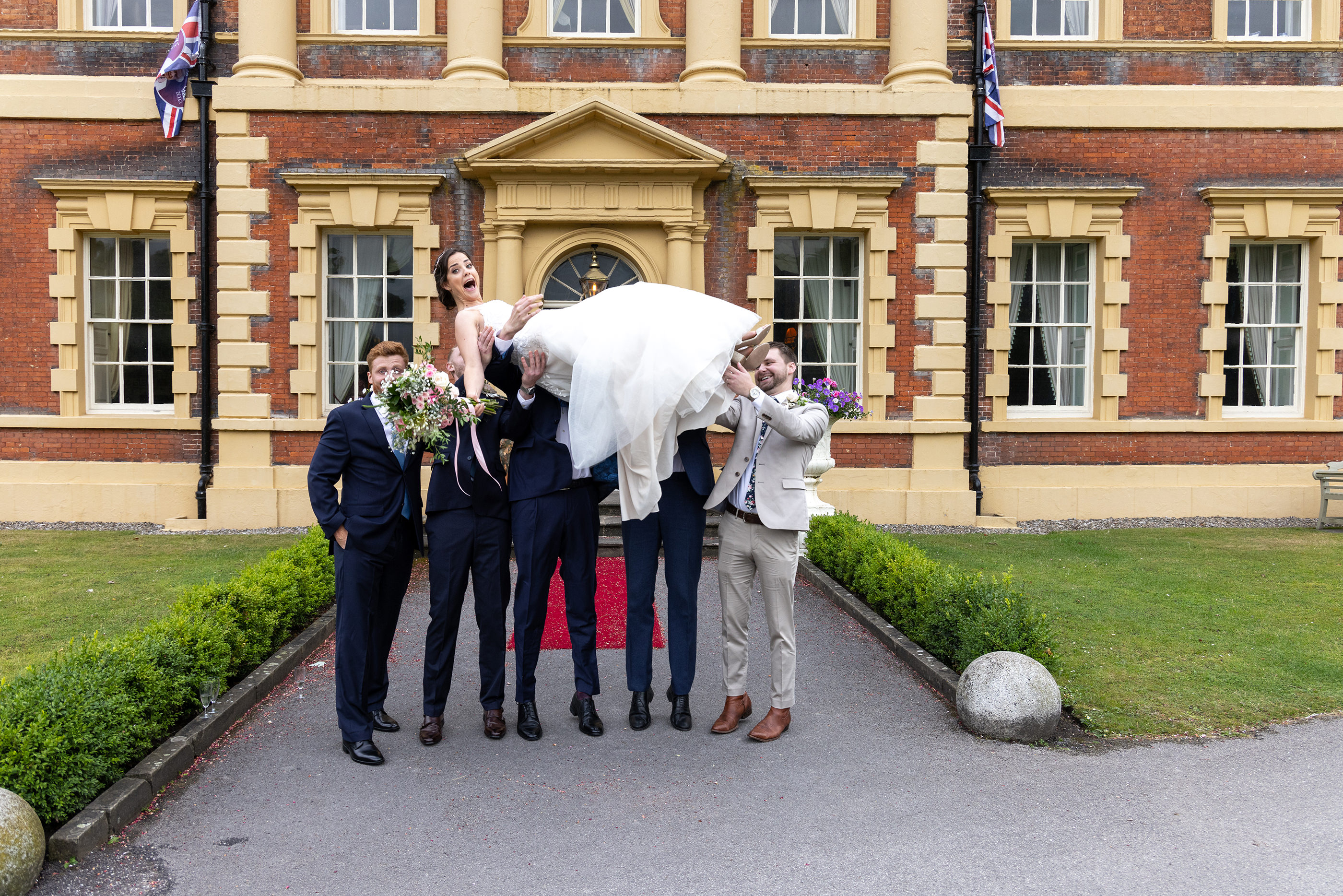 The bridesmaid getting thrown in the air by the groomsmen