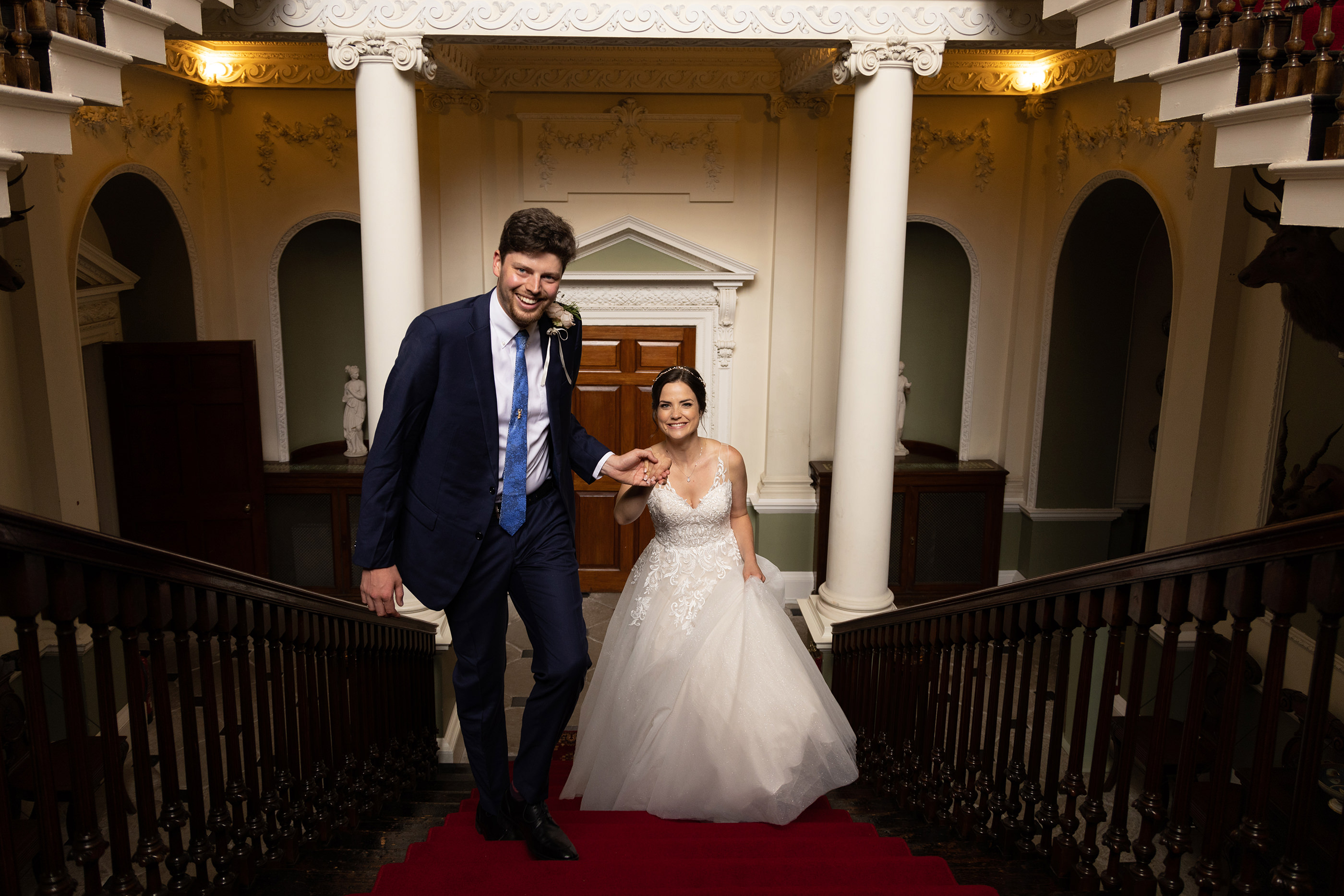 The bride and groom walking off the great staircase in Lytham Hall 