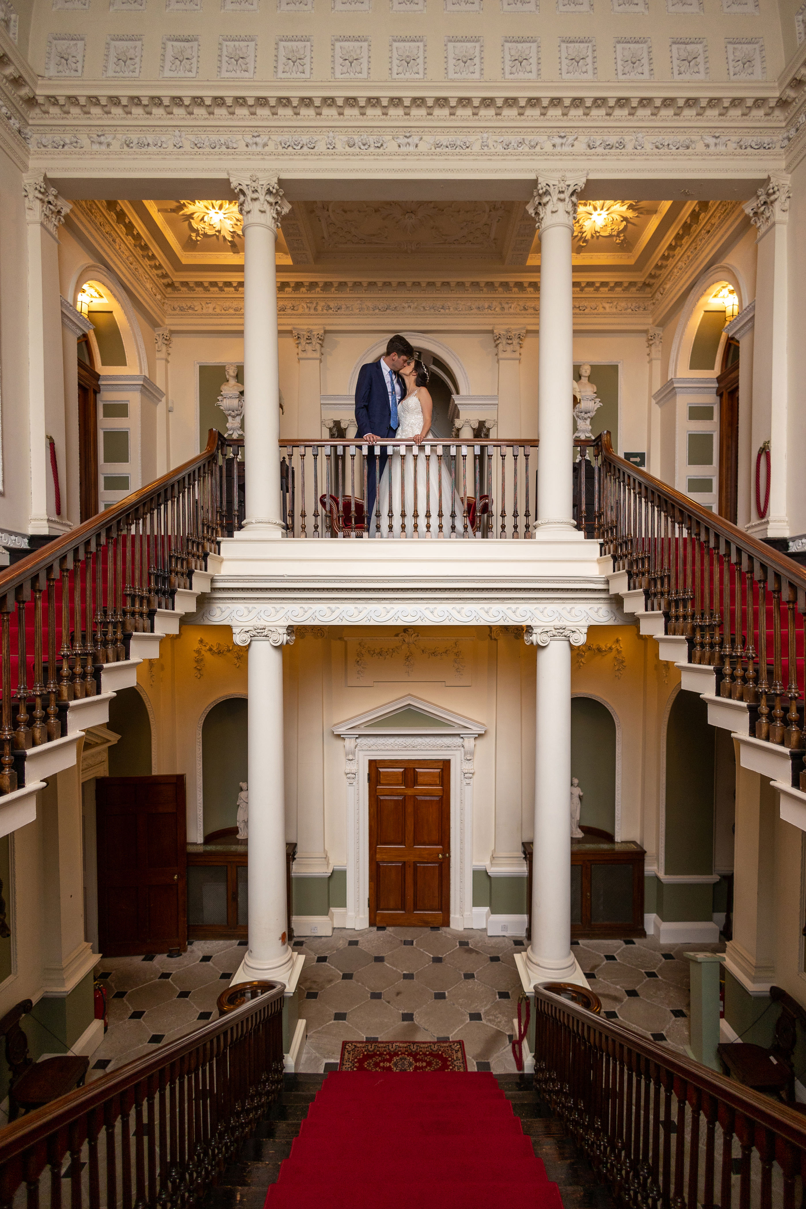 The bride and groom pose for a photo on the balcony 