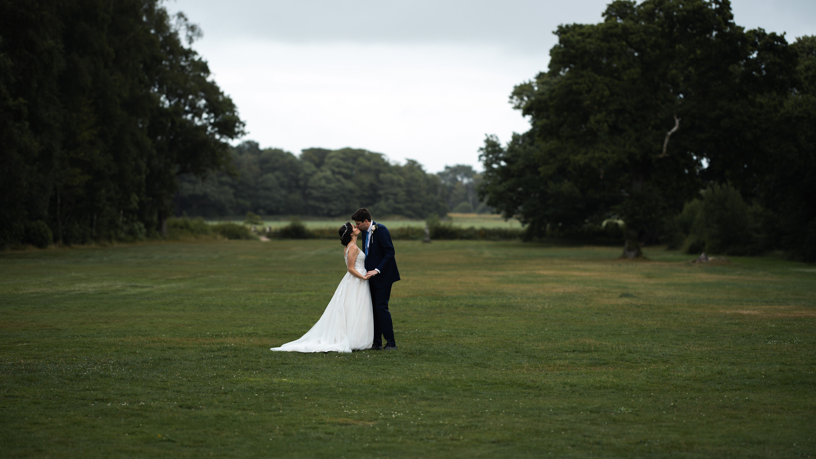 Bride and groom having a kiss on the lawn 