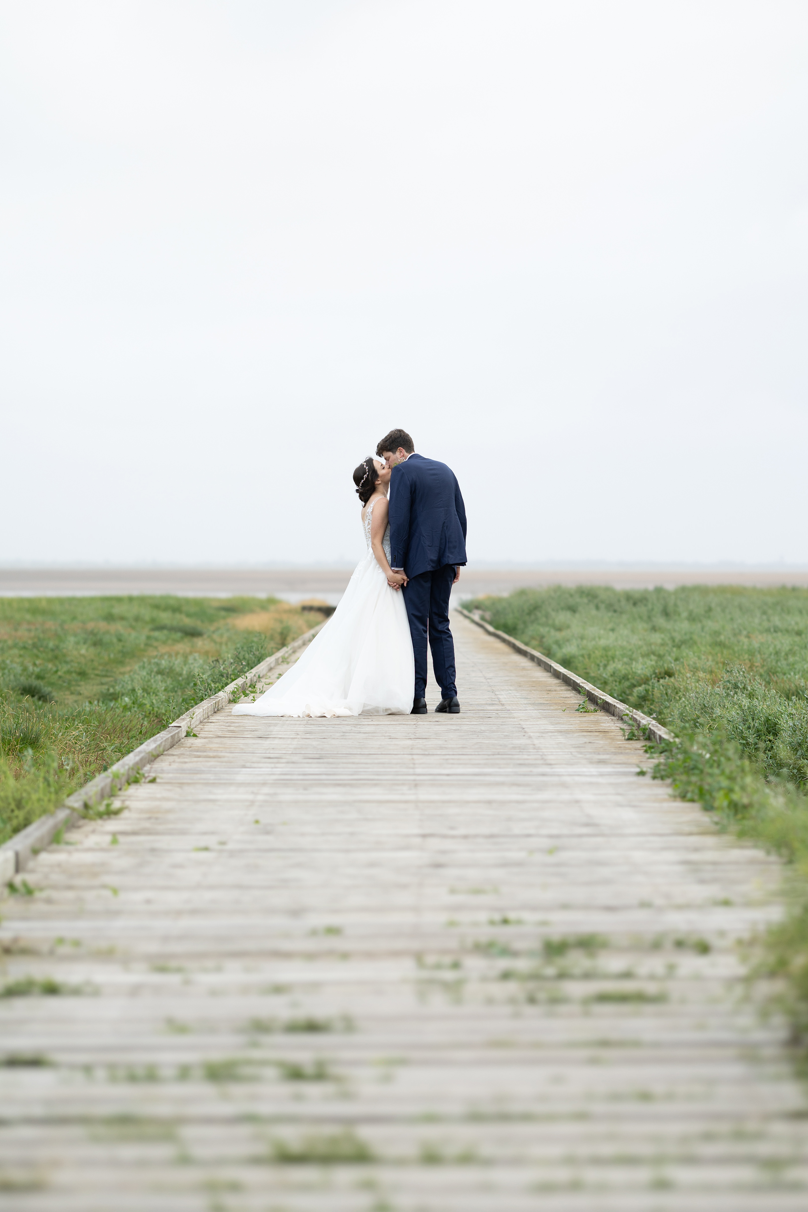 The bride and groom kiss on Lytham jetty 