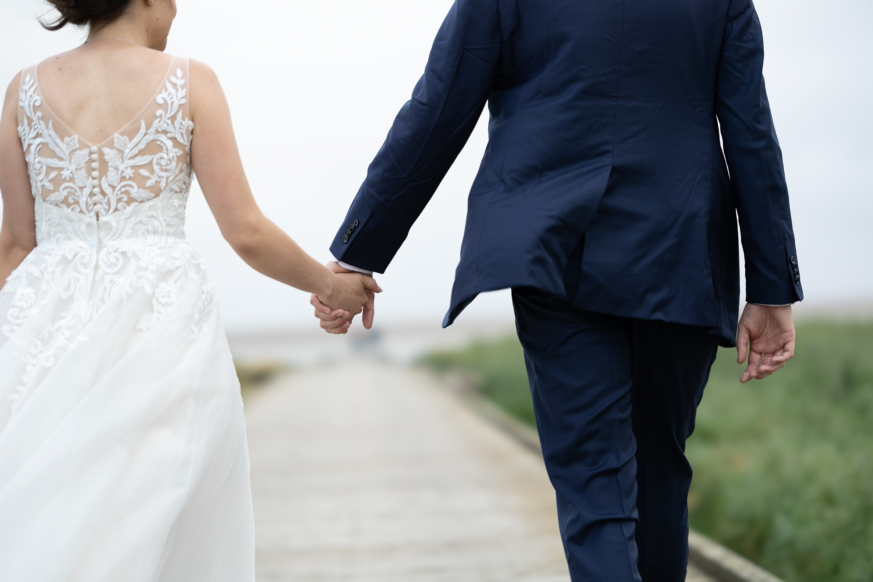 The bride and groom walk hand in hand 