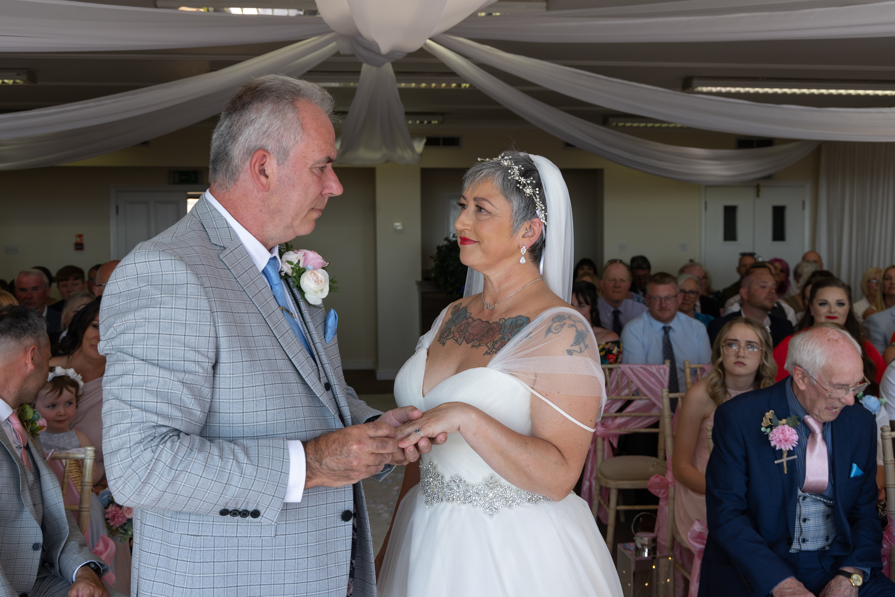 The bride and  groom exchange wedding rings 