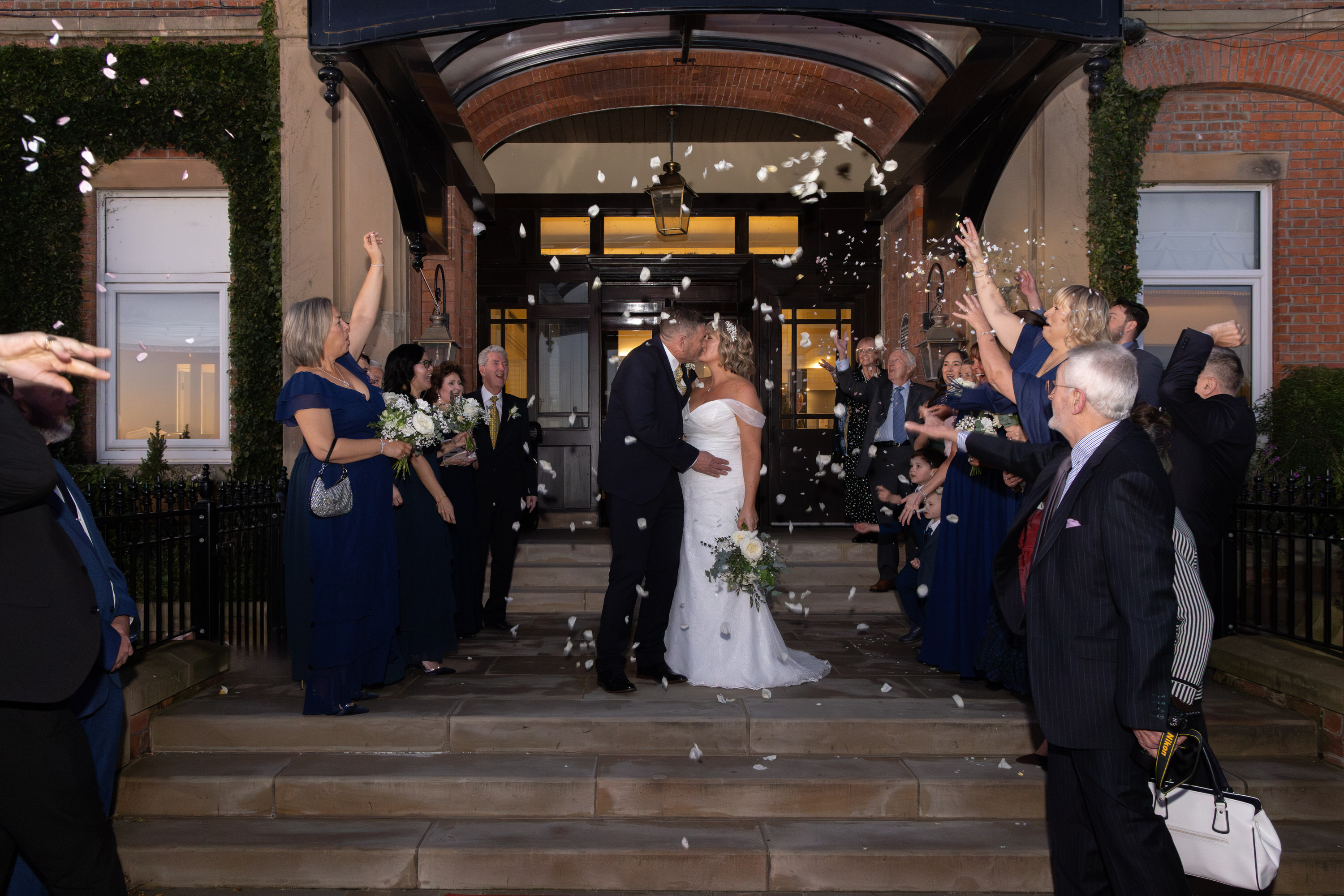 The guests throw confetti at the bride and groom 