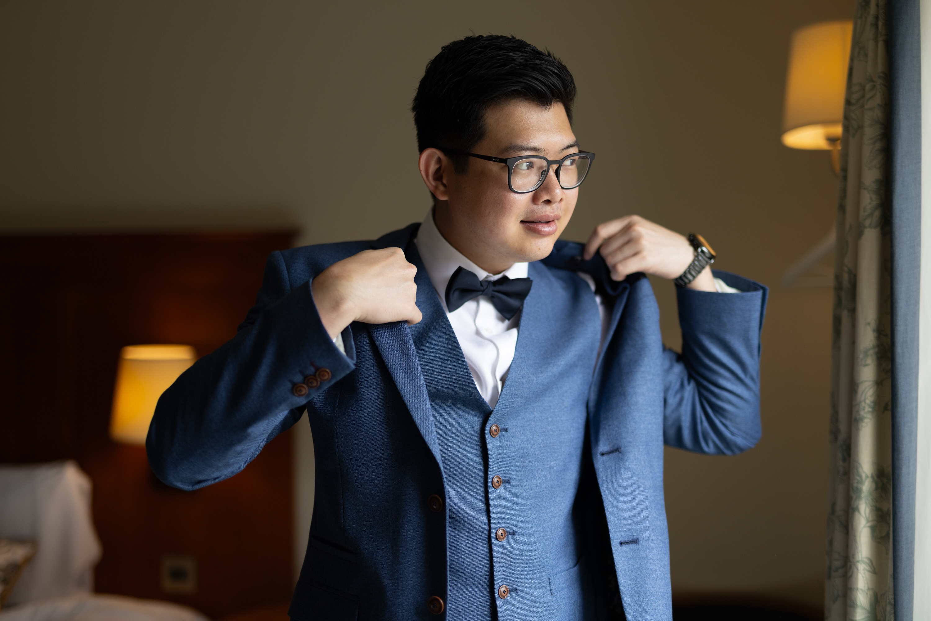 The groom puts on his jacket 