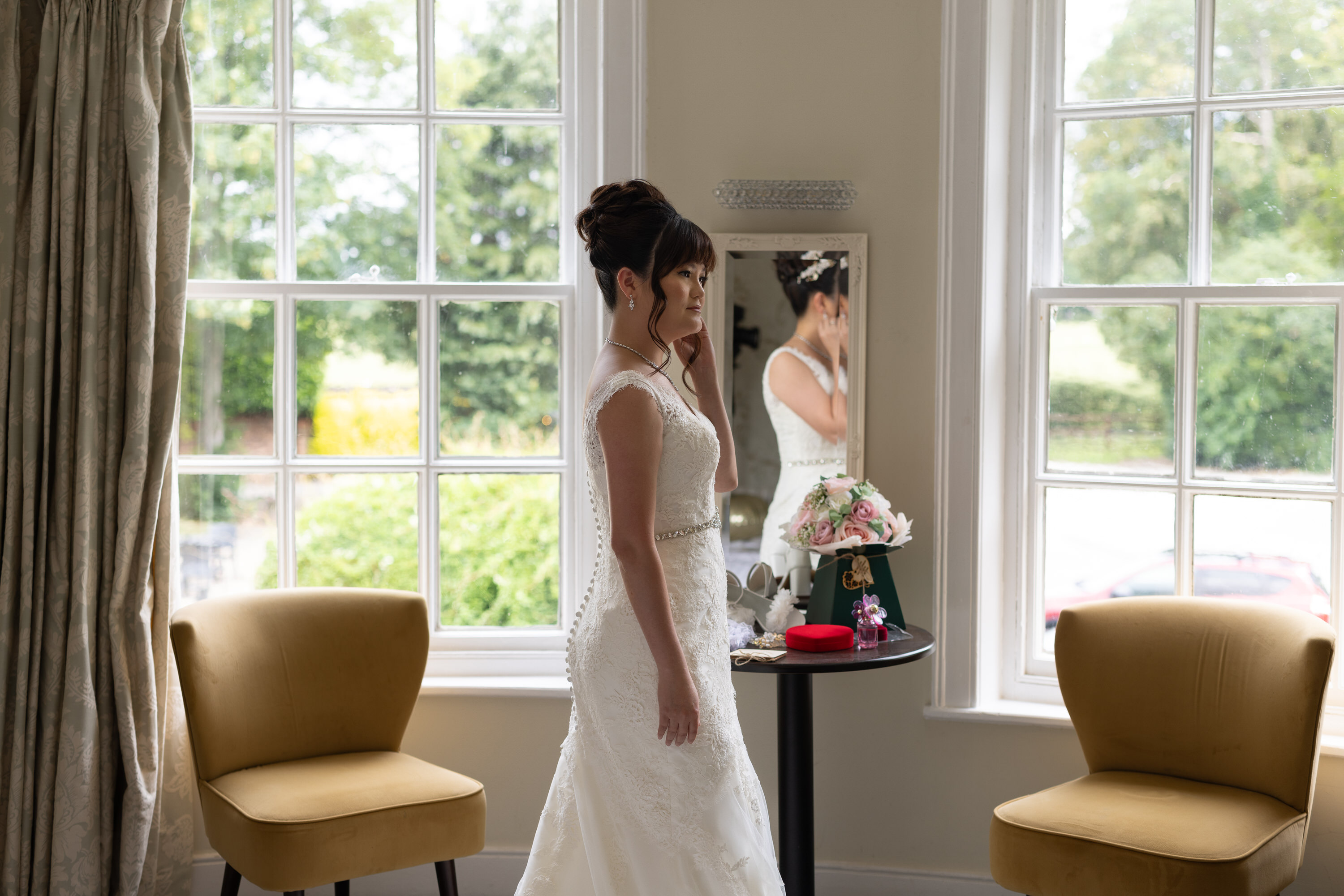The Bride putting on her earrings ready for the wedding 