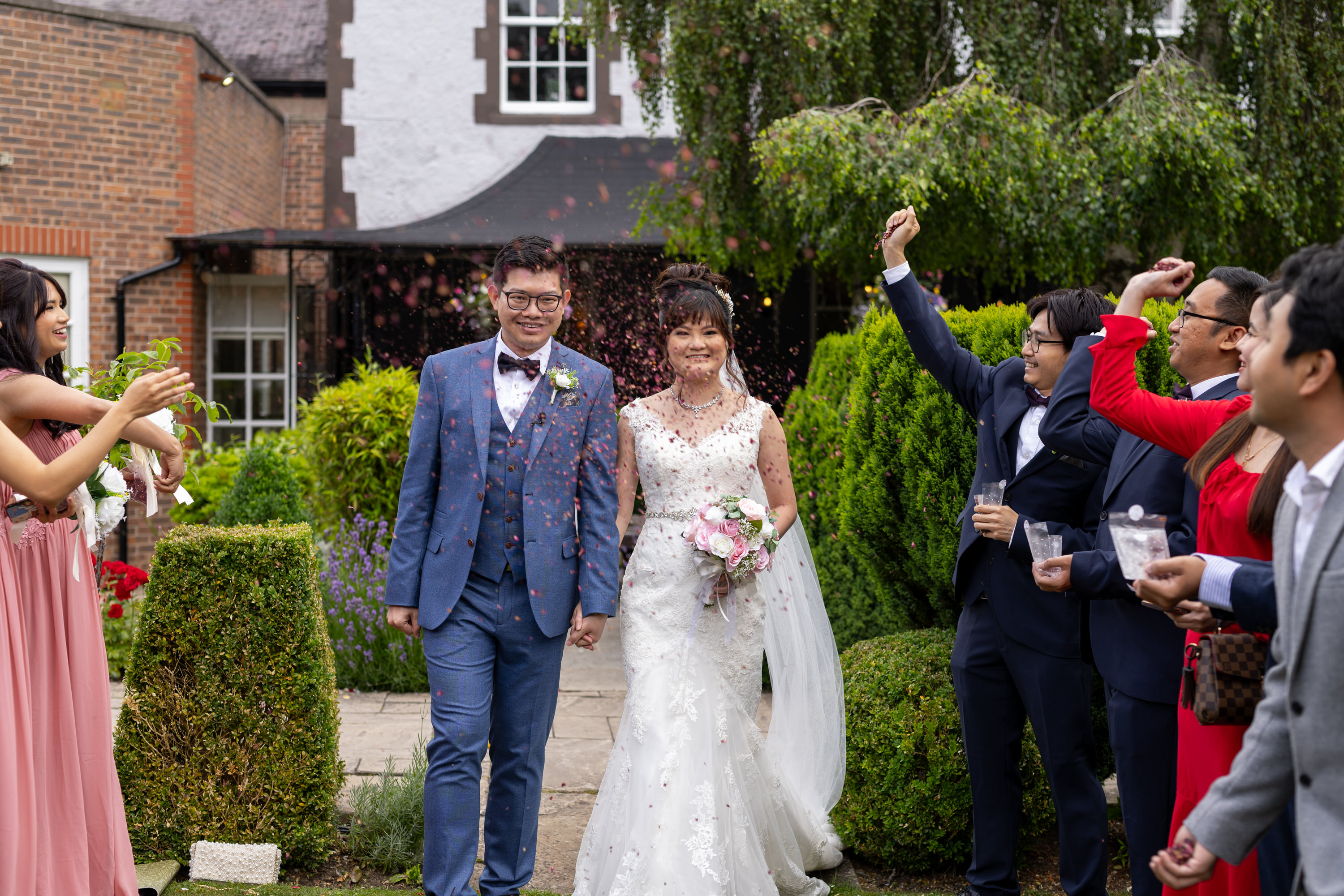 The wedding guests throw confetti at the bride and groom 