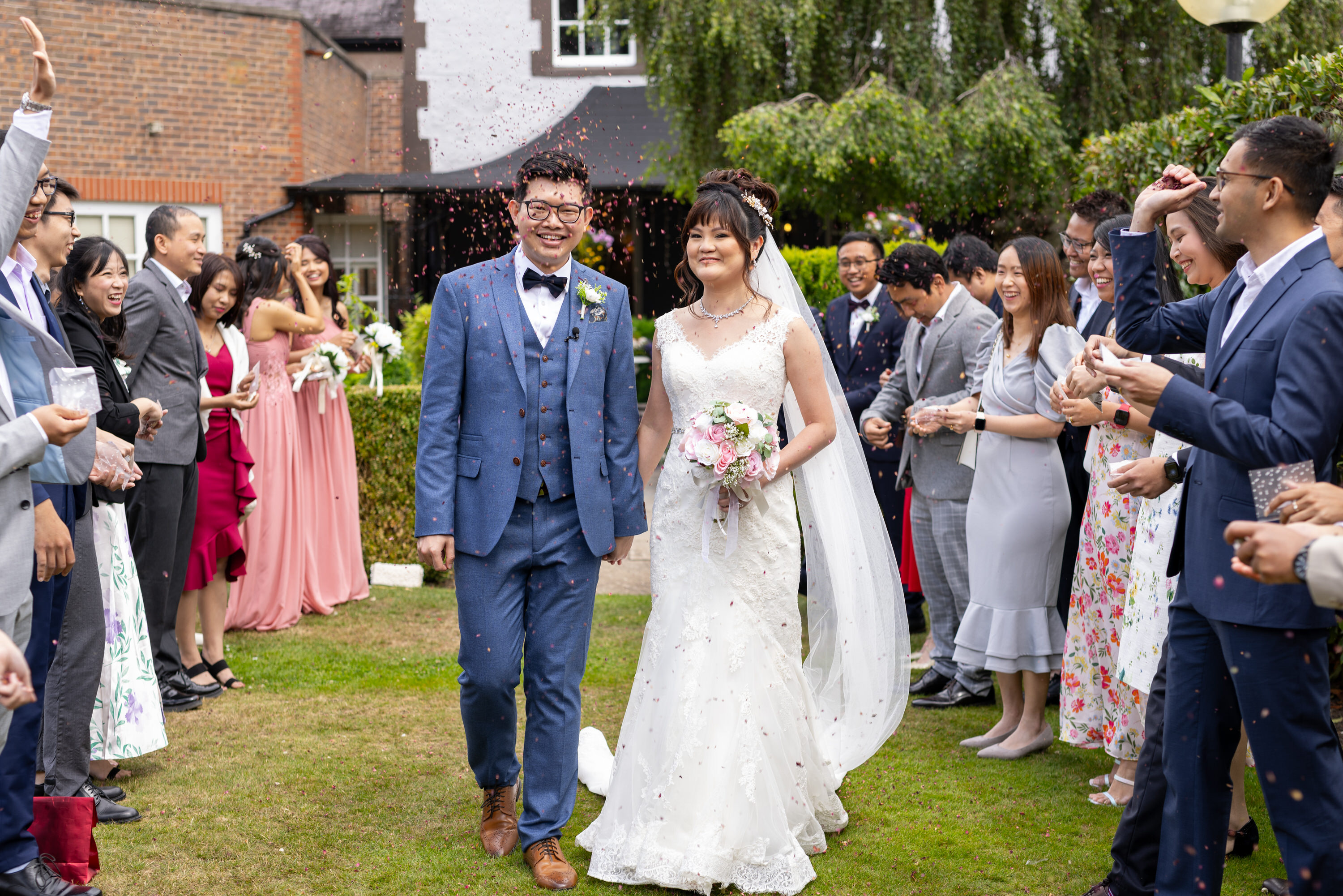 The wedding guests throw confetti at the bride and groom 