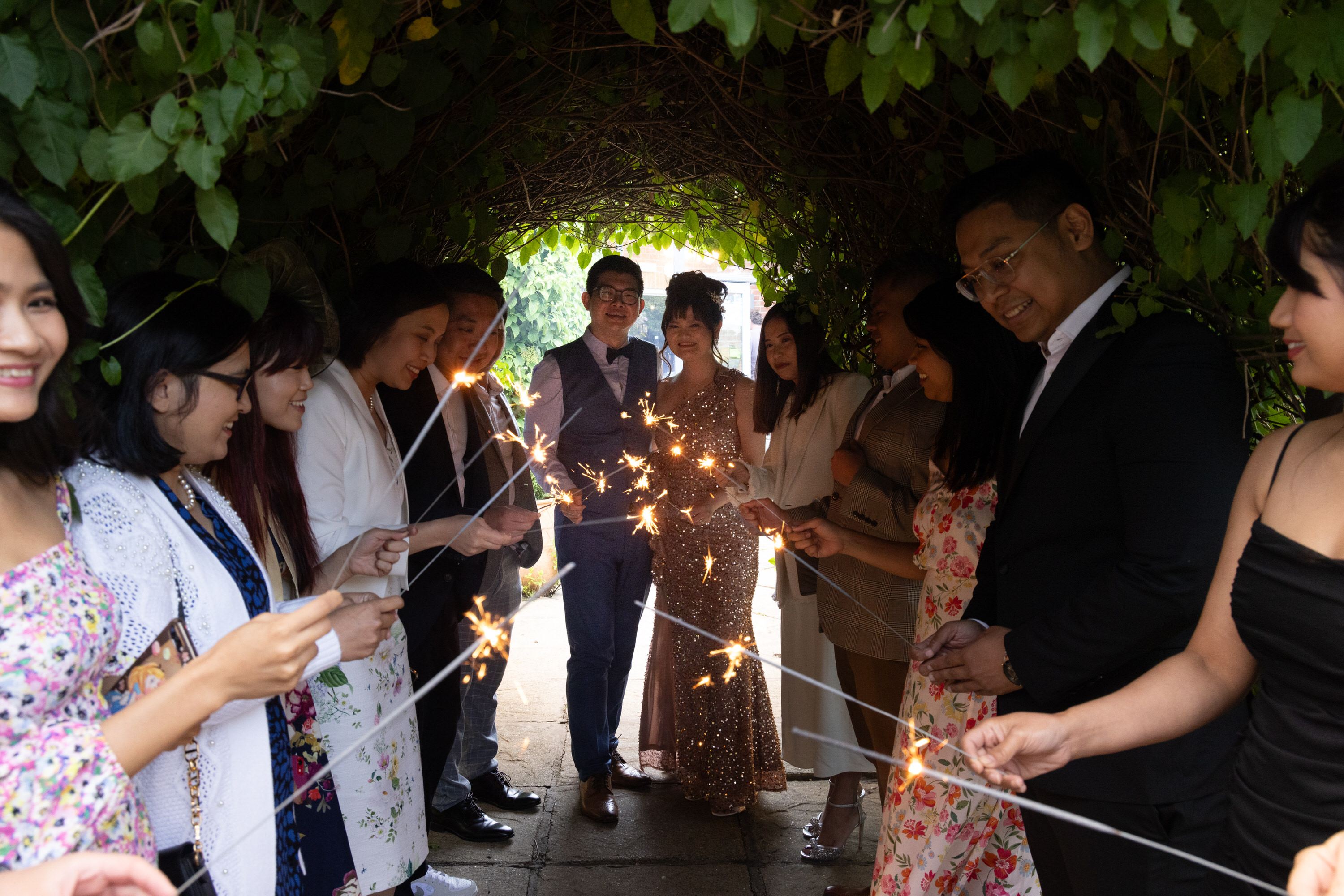The bride and groom and wedding guests light the sparklers