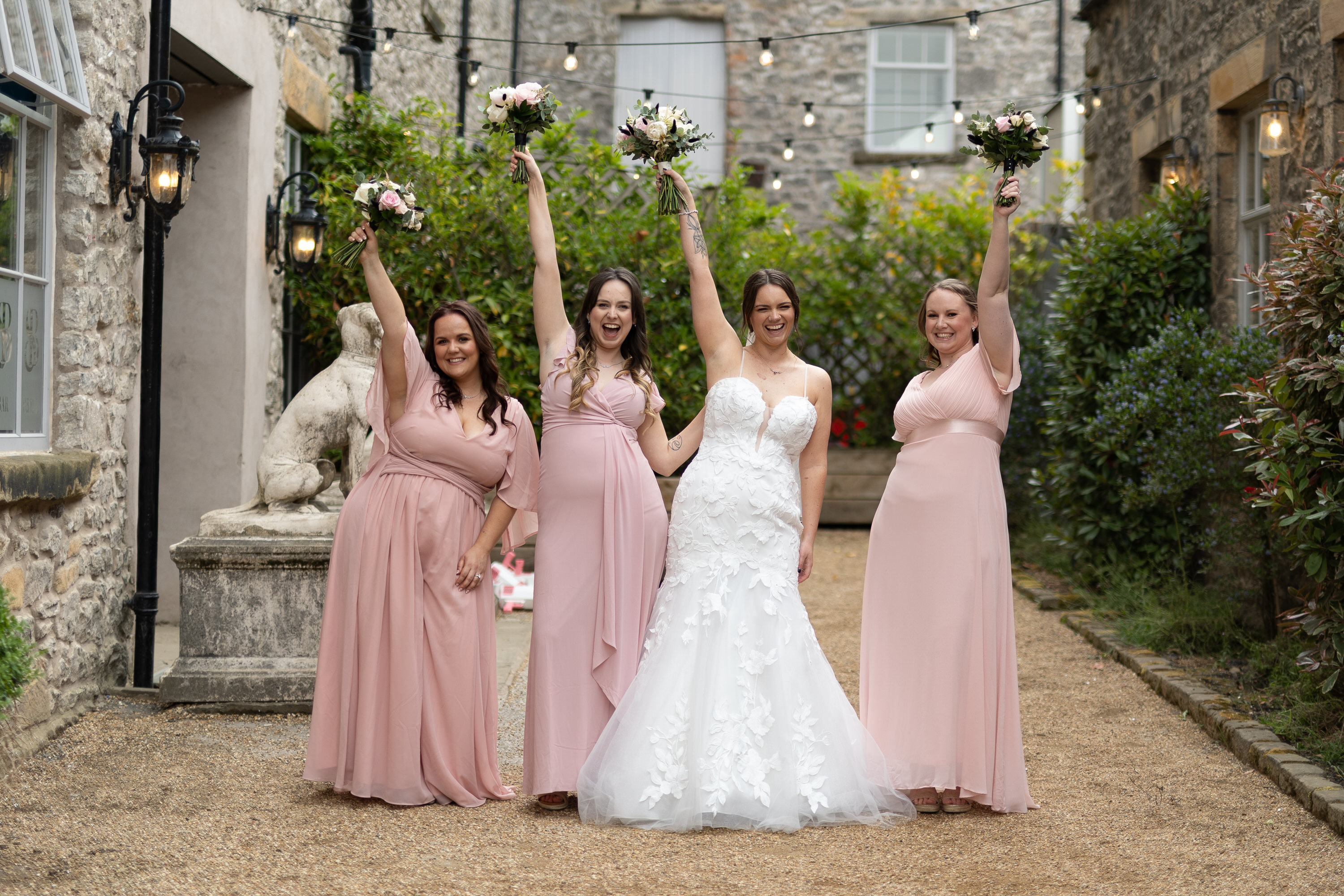 Sarah and her bridesmaids holding their bouquets 