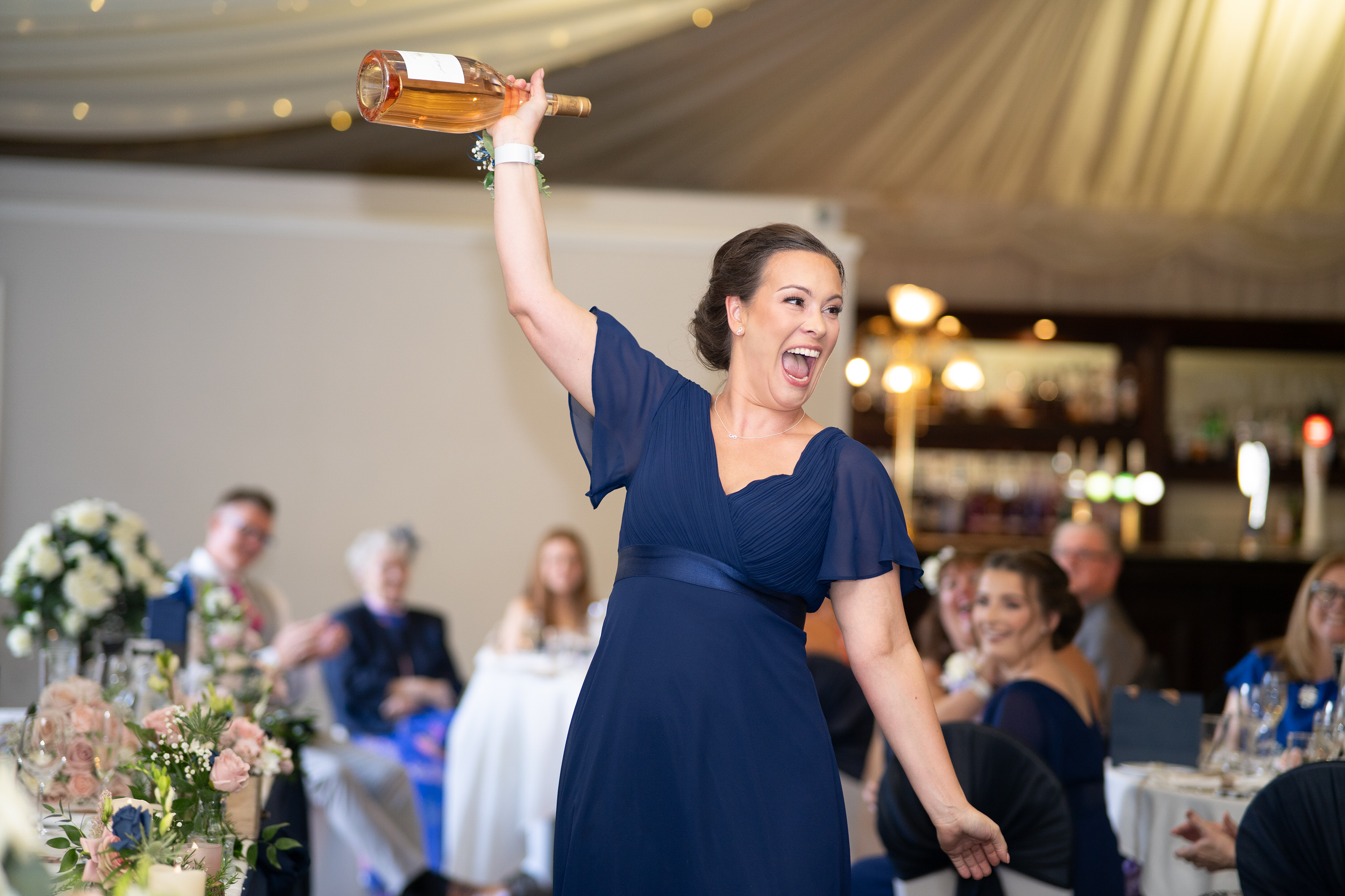 The bridesmaid  winds a bottle of wine