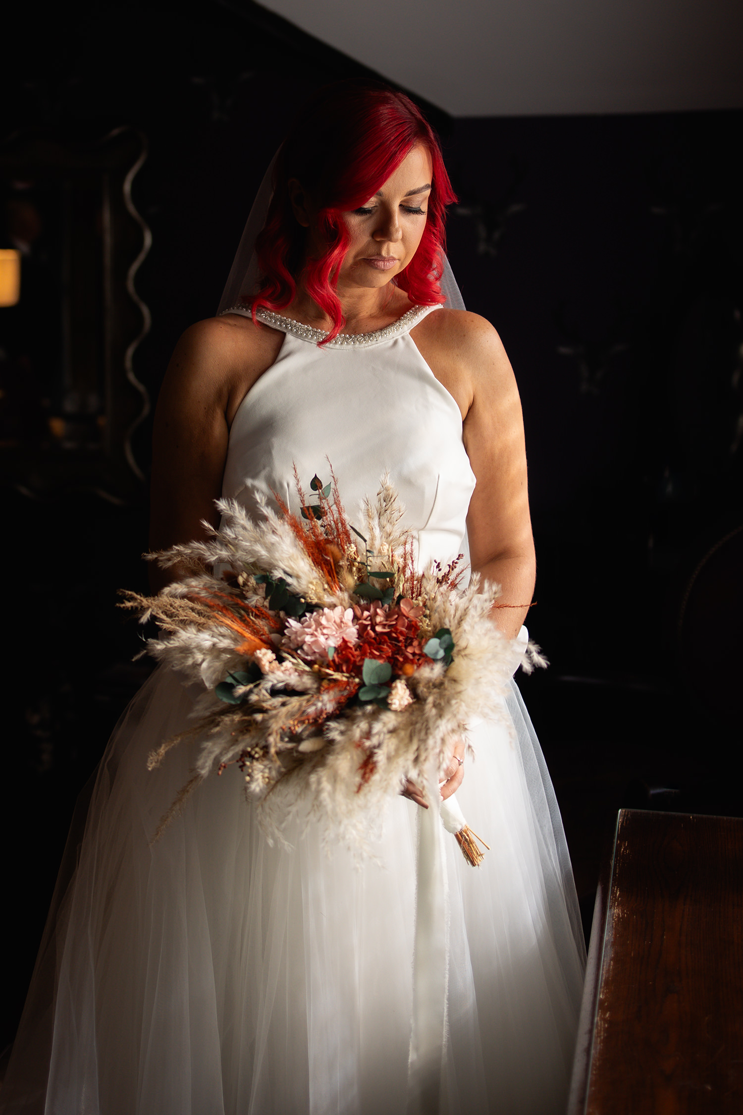 The bride looking down at her bouquet 