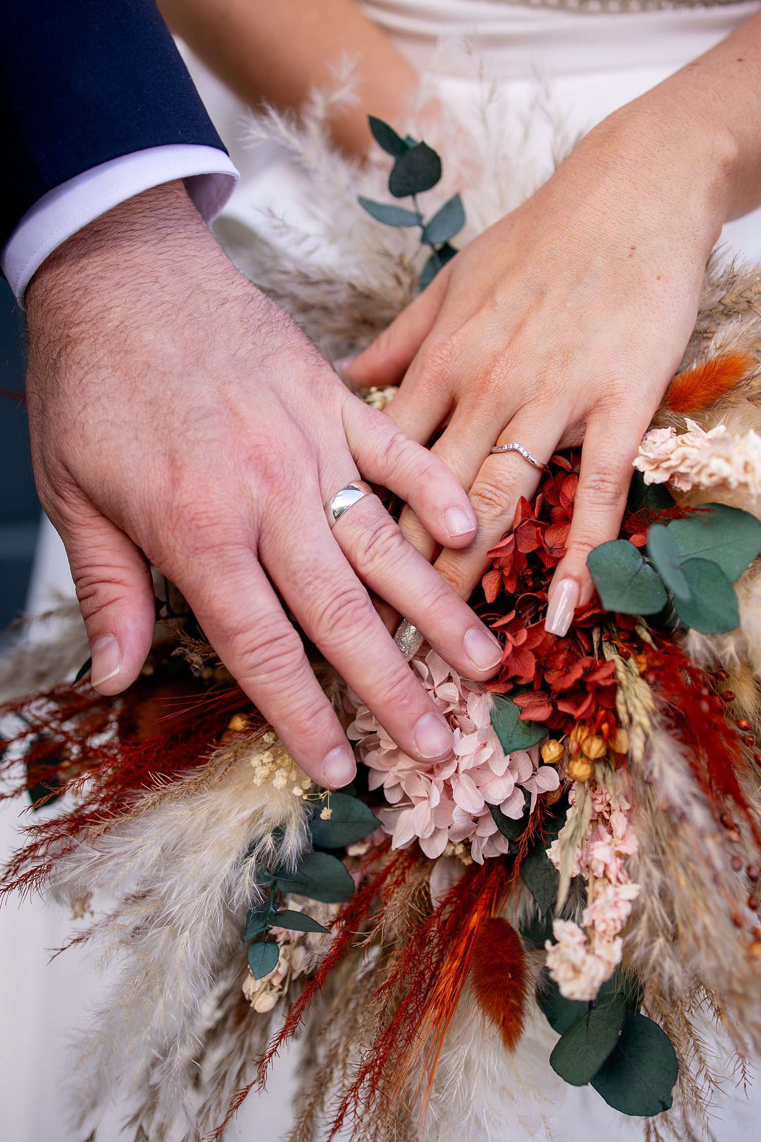 The bride and groom show off their wedding rings 