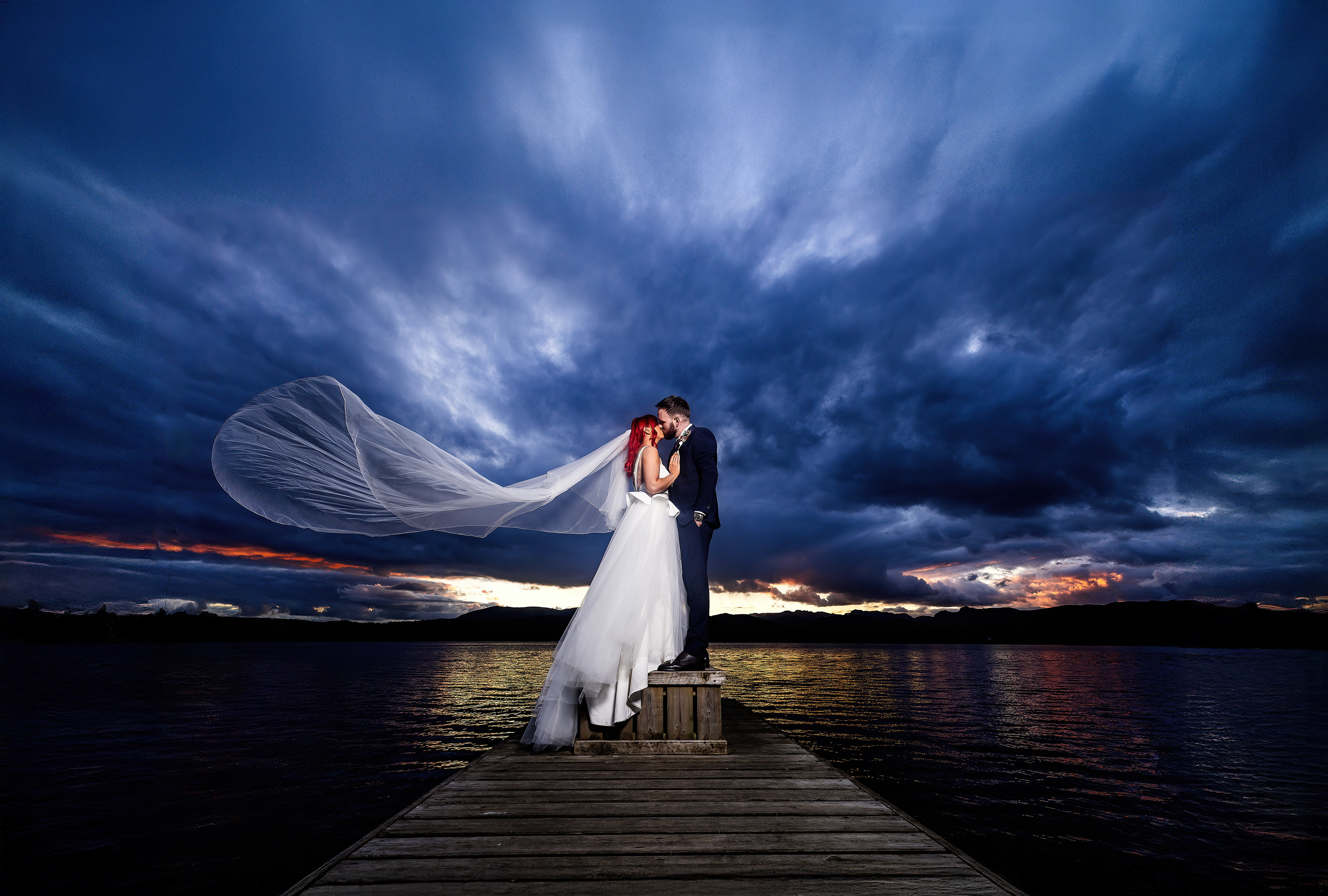 Bride and groom on the edge of Lake Windermere 