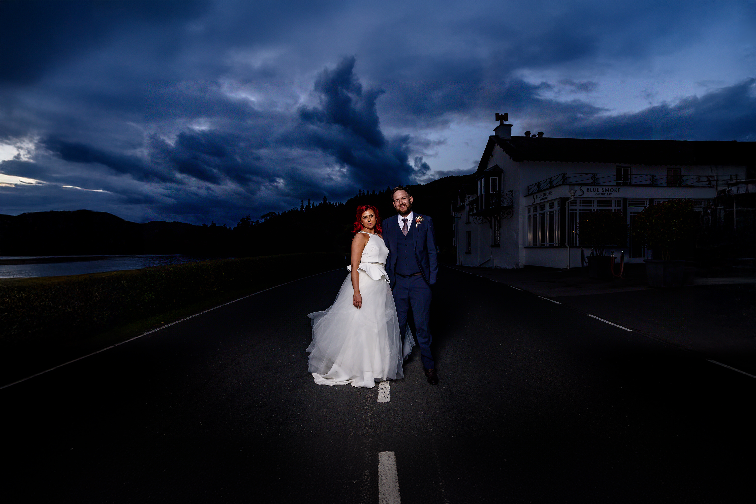 Bride and groom on the edge of Lake Windermere 