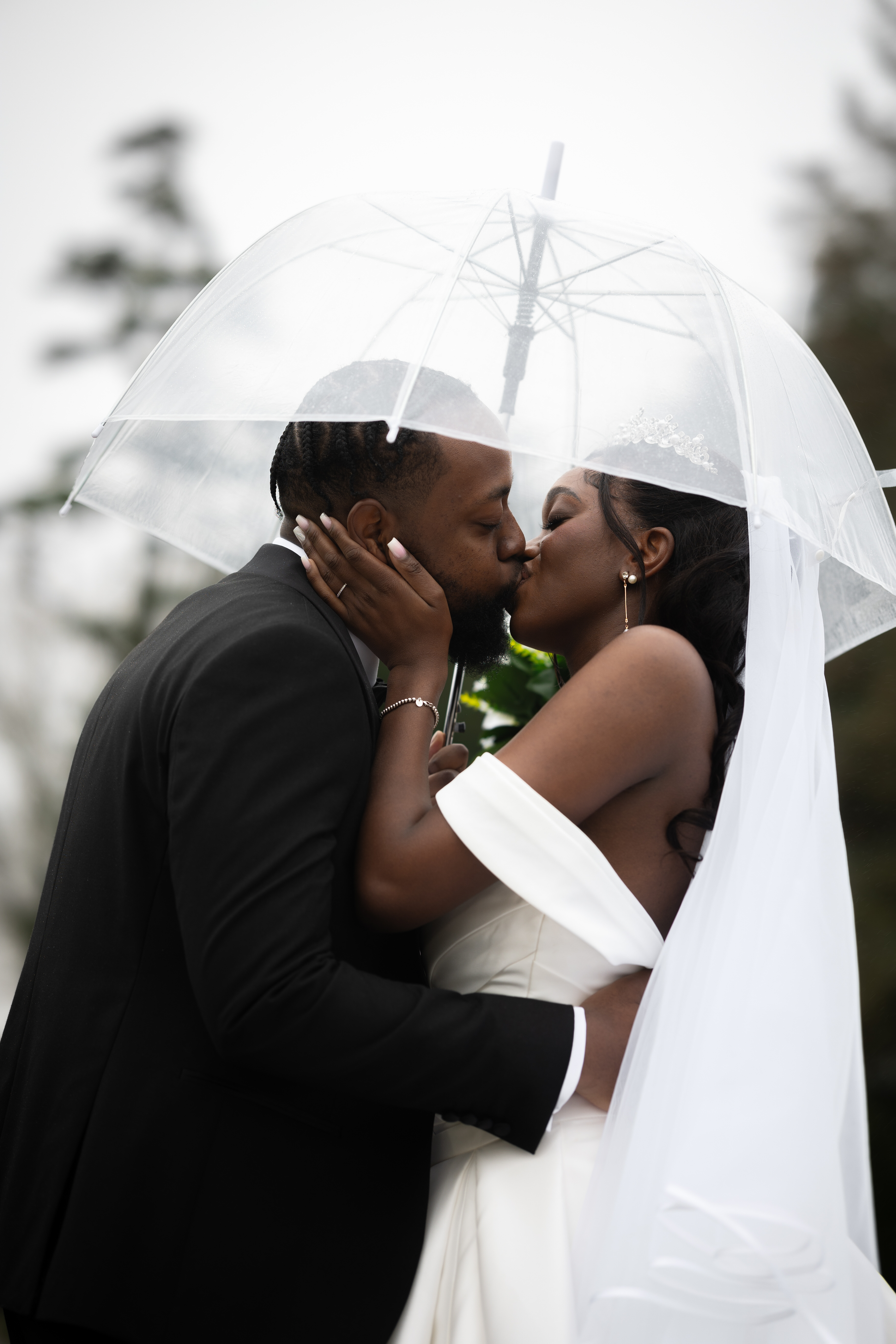The bride and groom have a kiss in the rain 