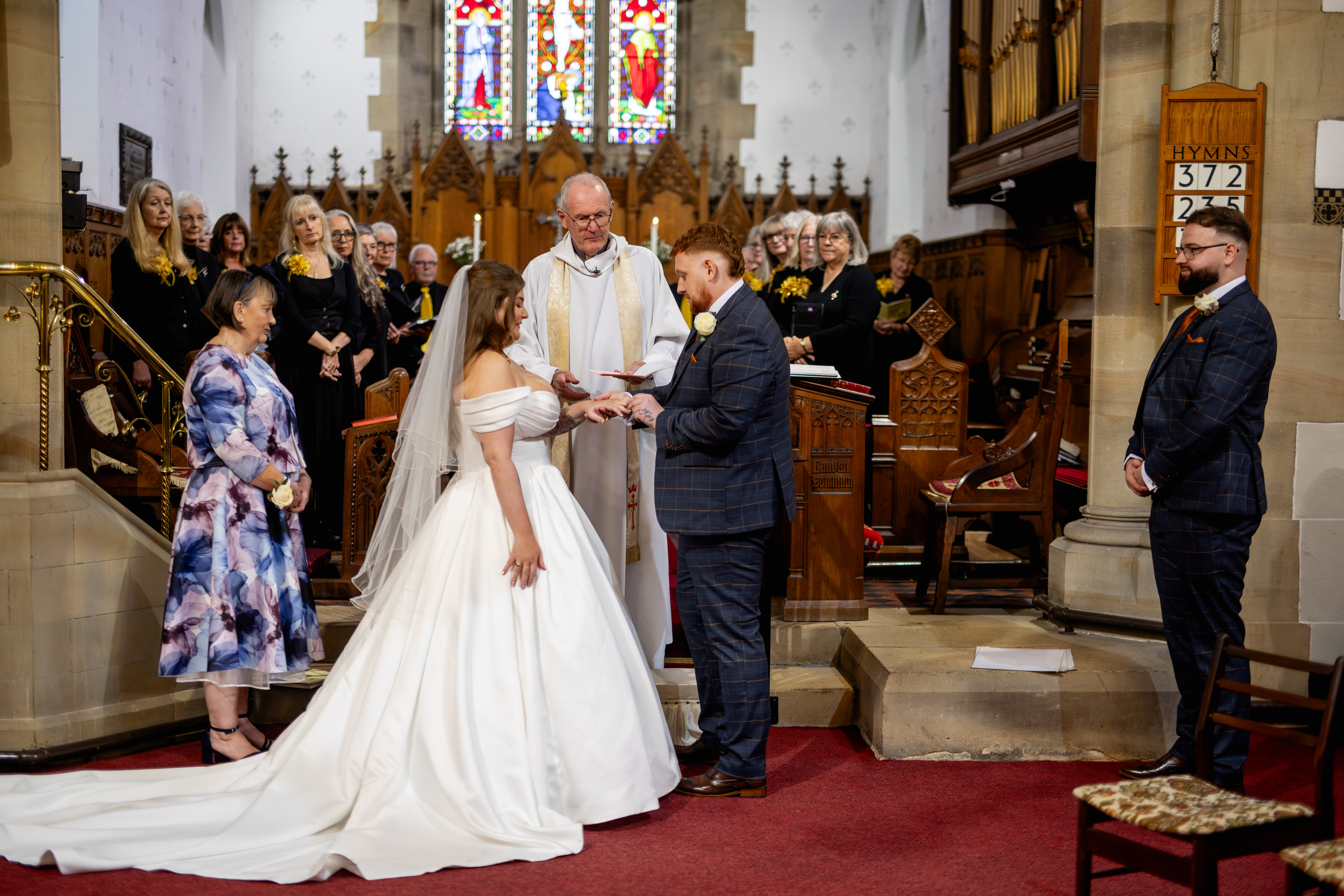 The groom Samuel puts the wedding ring on his brides finger