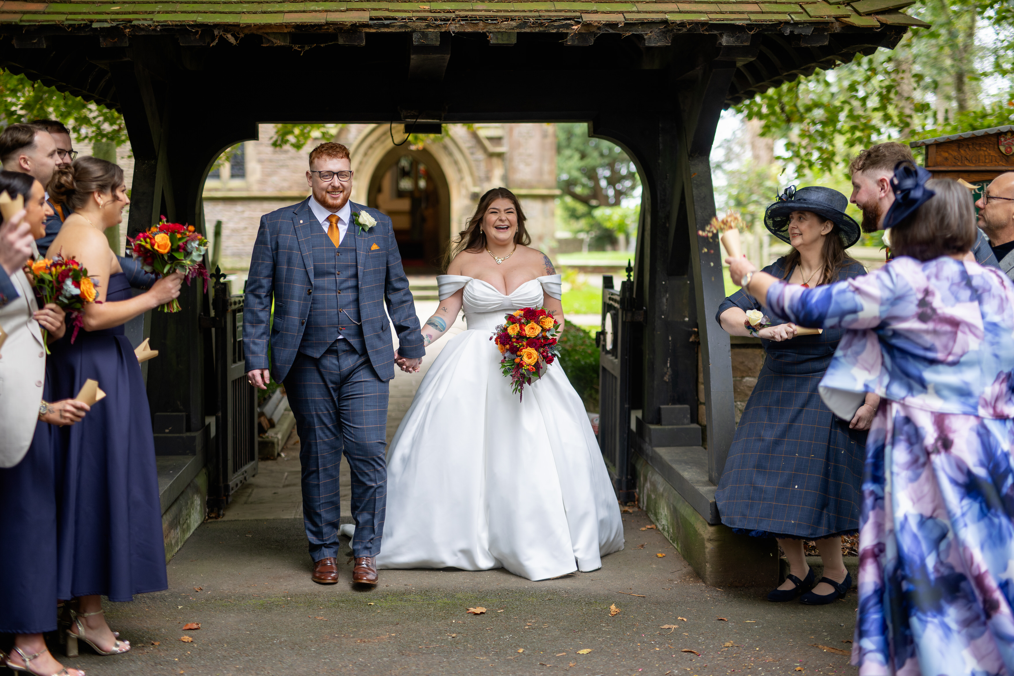 The bride and groom walk out to be greeted with confetti 