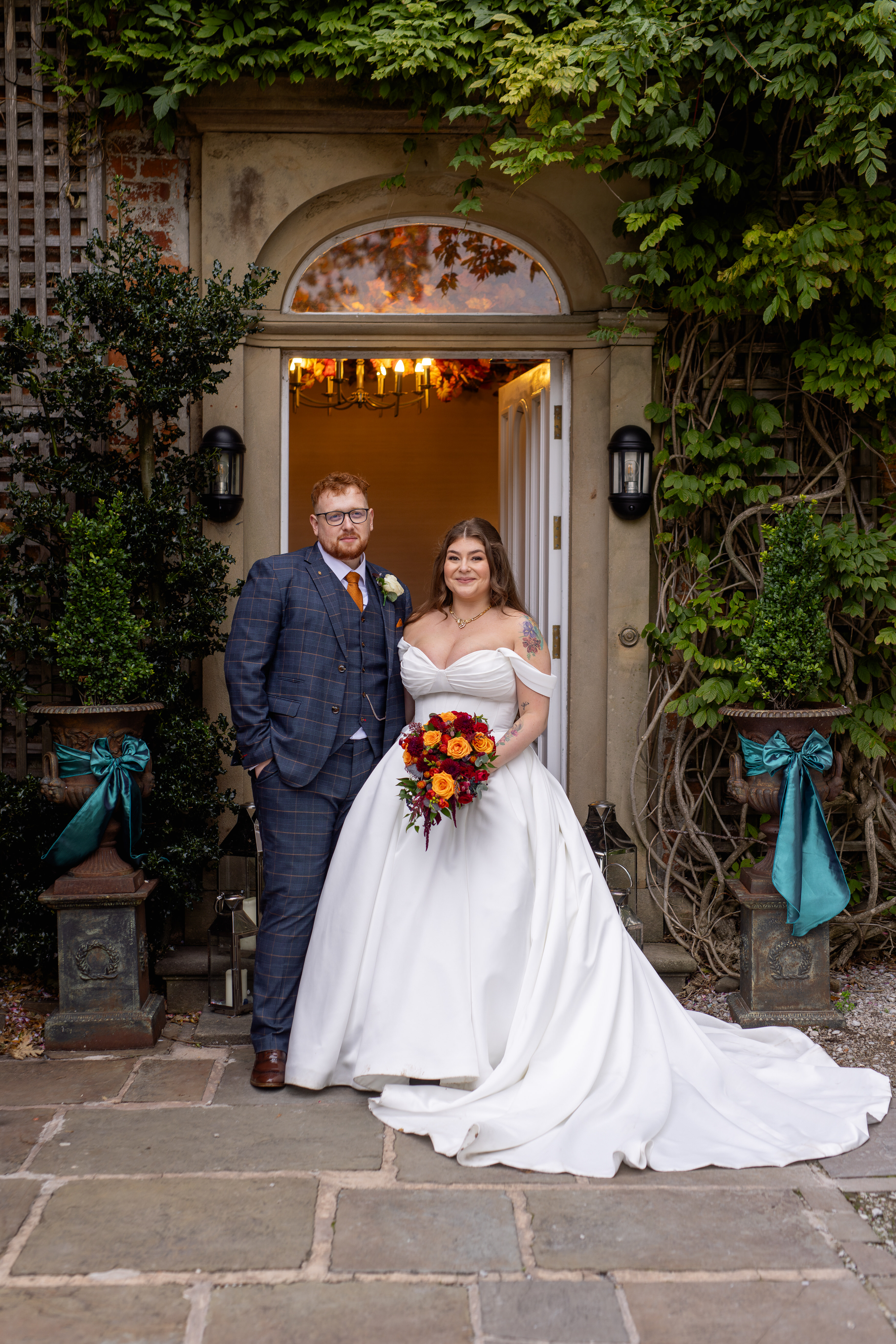 Leila and Samuel have their photo taken at the front door to Singleton Lodge 