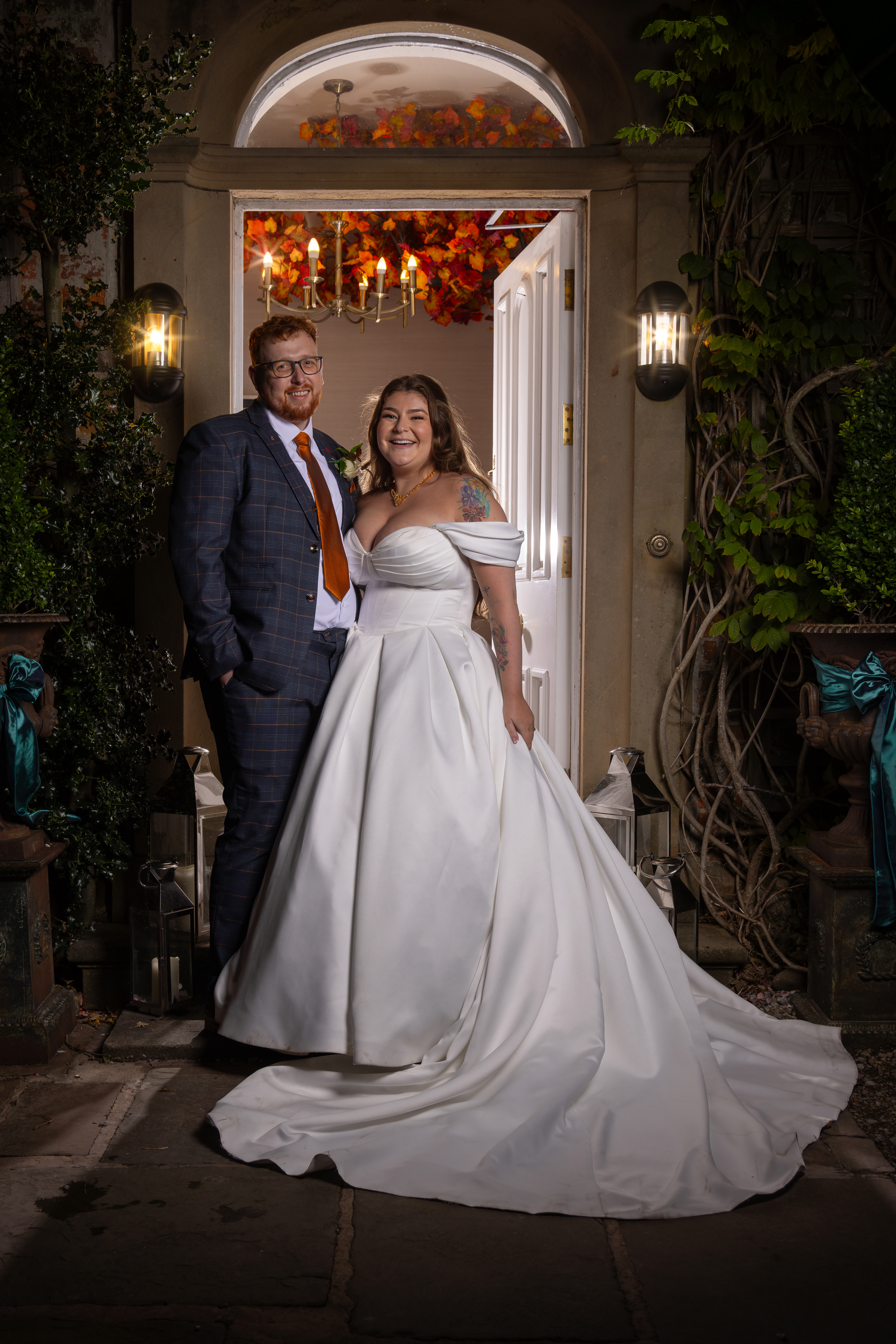 Leila and Samuel  have their photo taken in the evening outside Singleton Lodge 