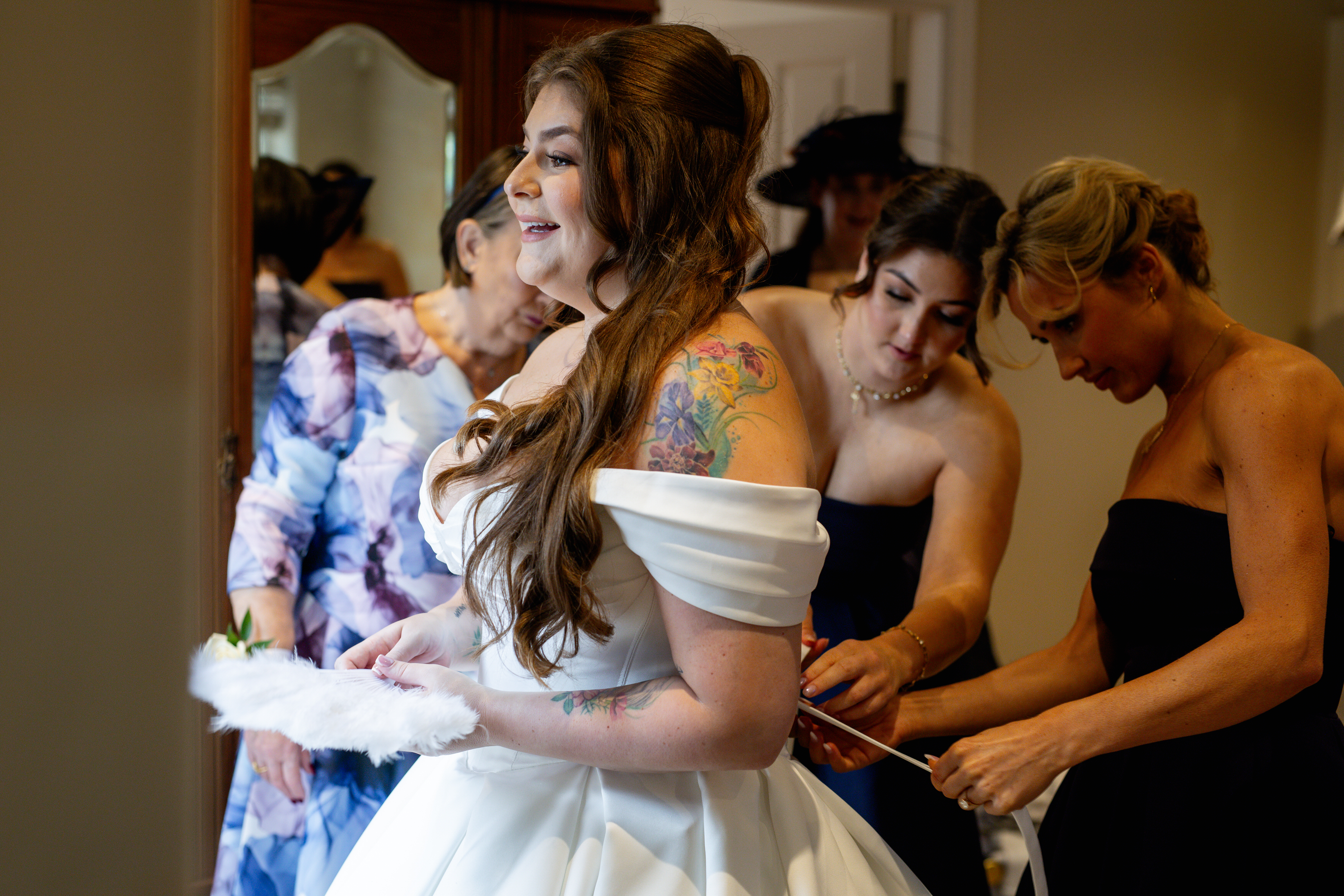 The Bride having her wedding dress put on 