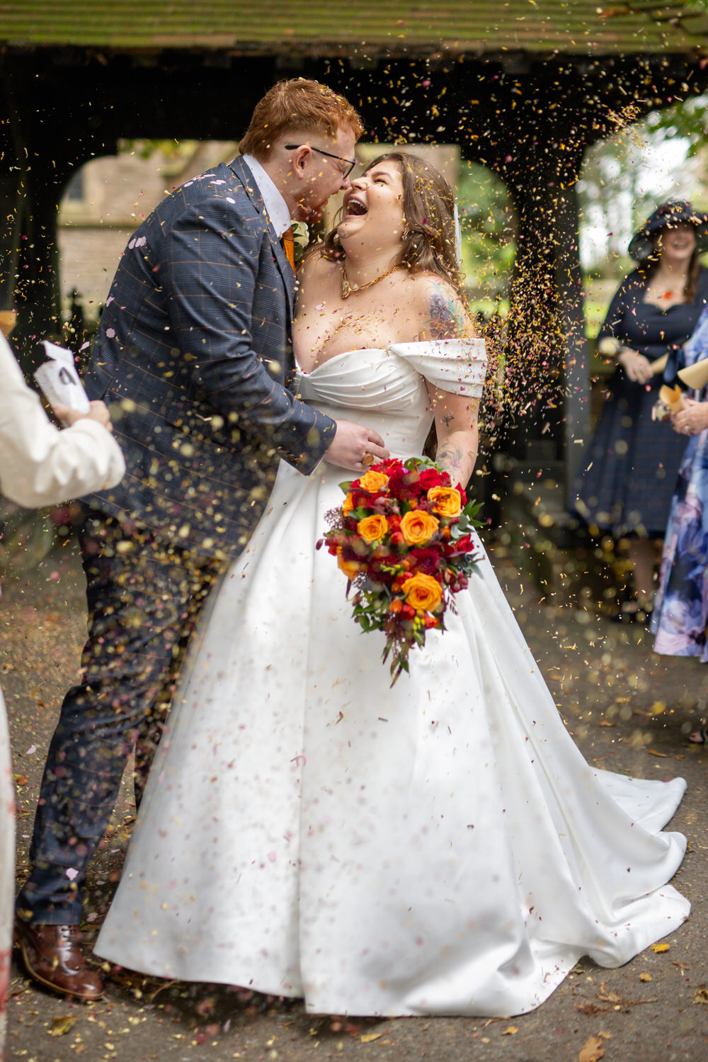 The guests throw confetti at the happy couple 