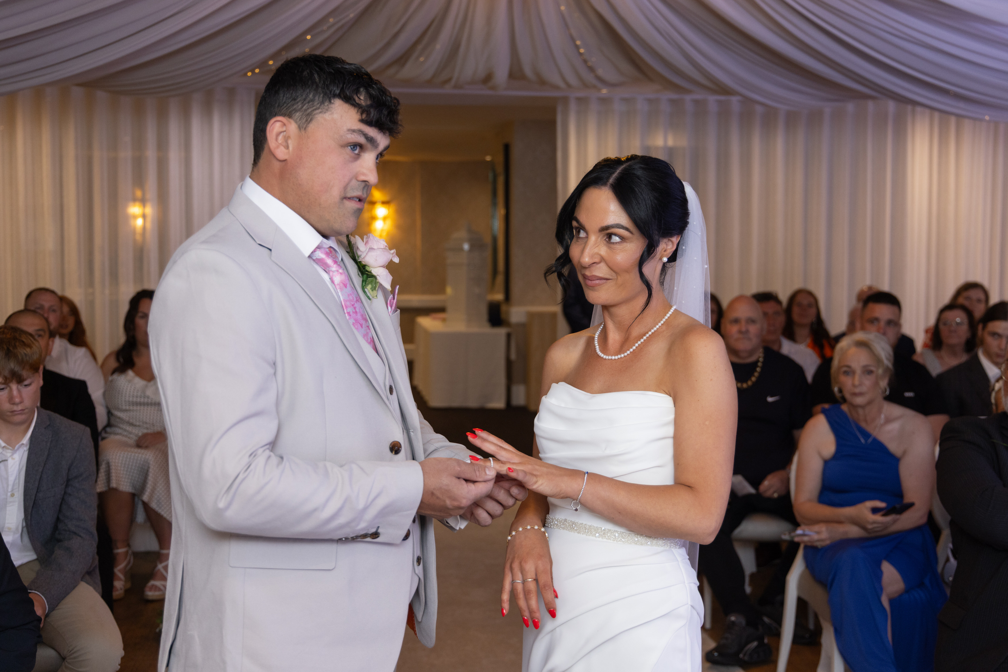 Andrew places the ring on Sarah's hand
