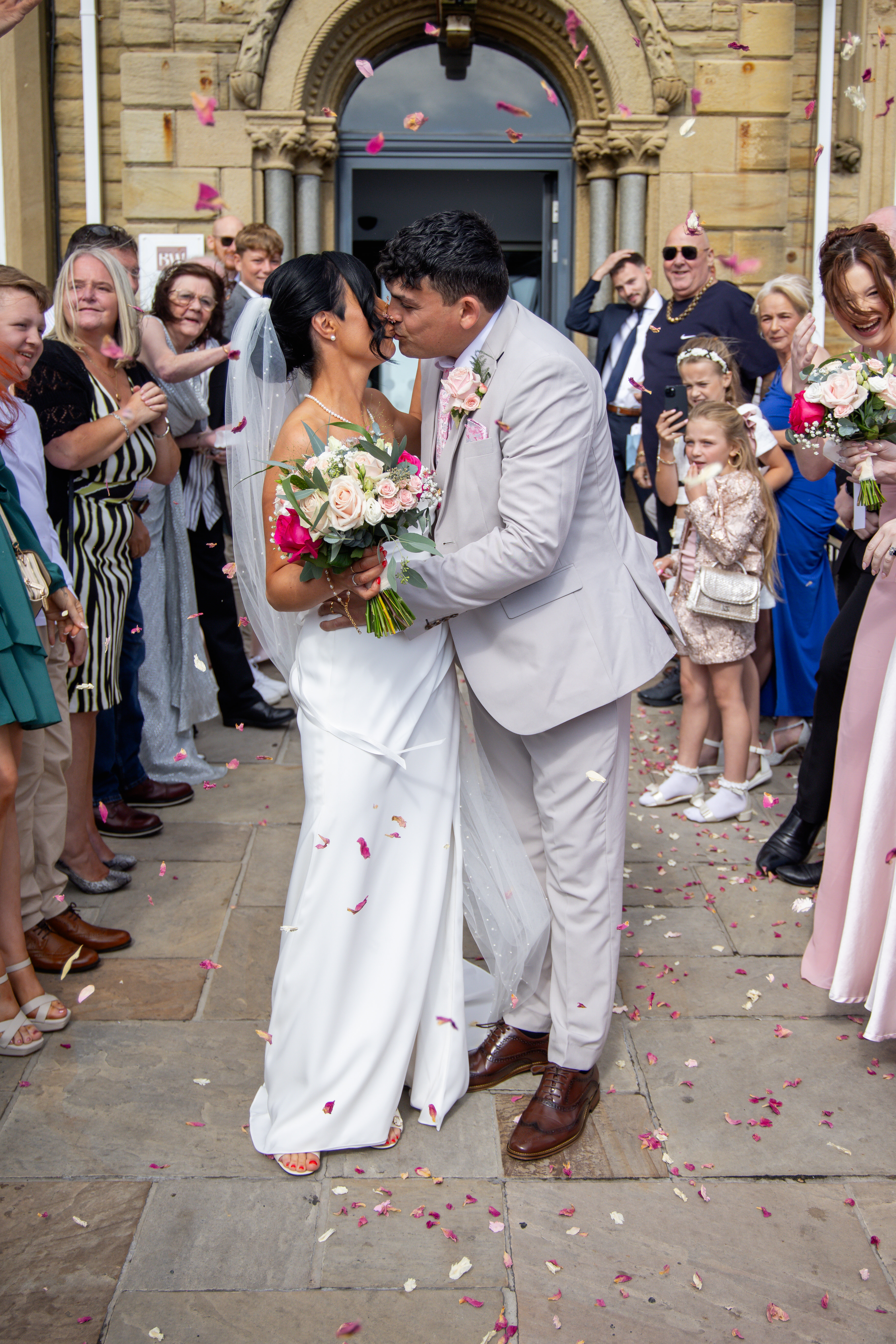 Sarah and Andrew are greeted by their guests throwing confetti at them 