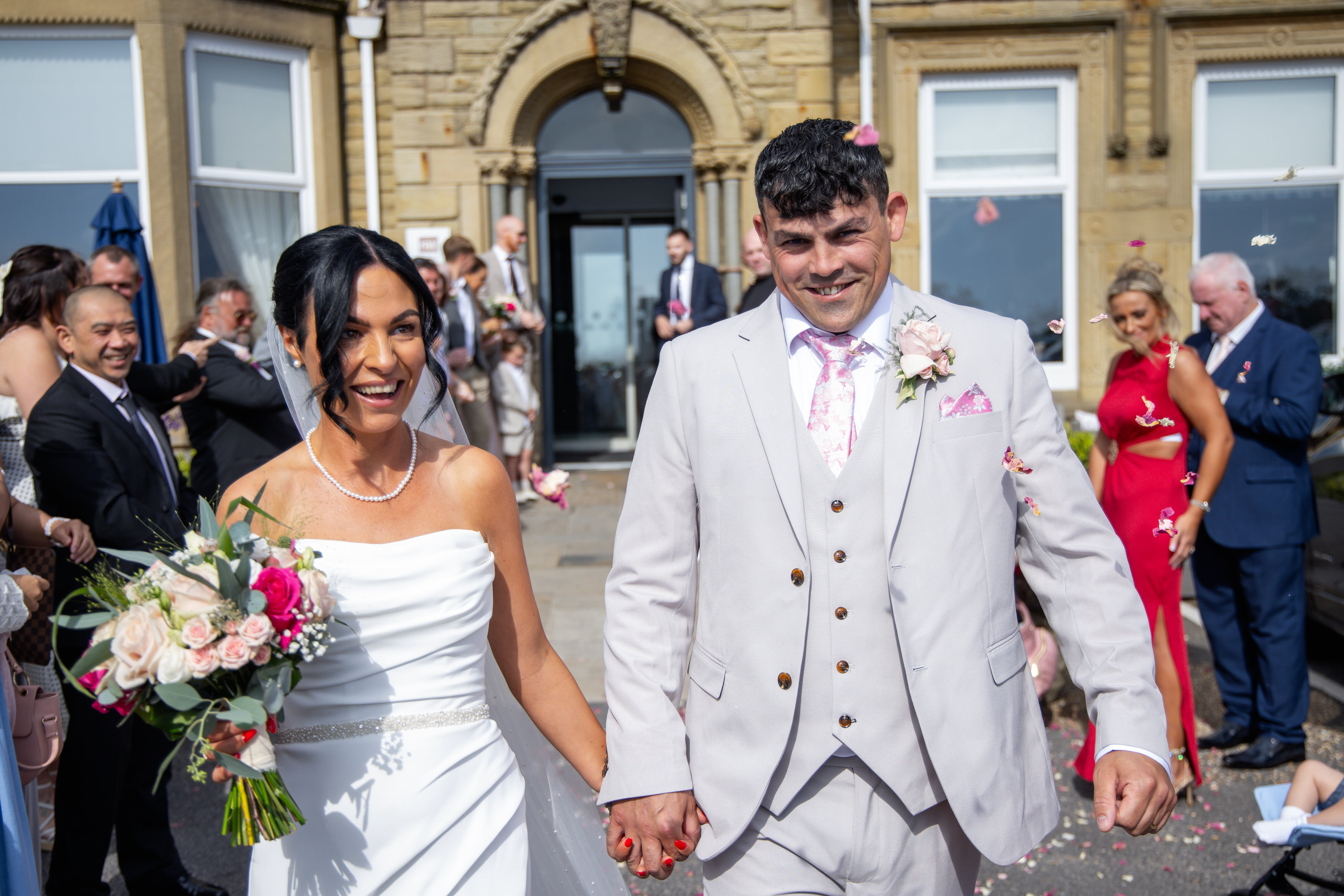 The guests throw confetti at the bride and groom 