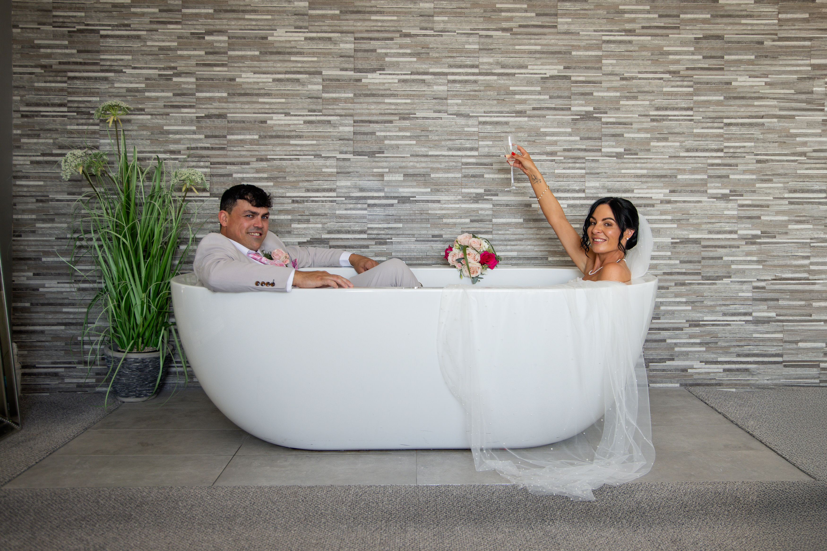 The bride and groom have a fun photo in the bath 