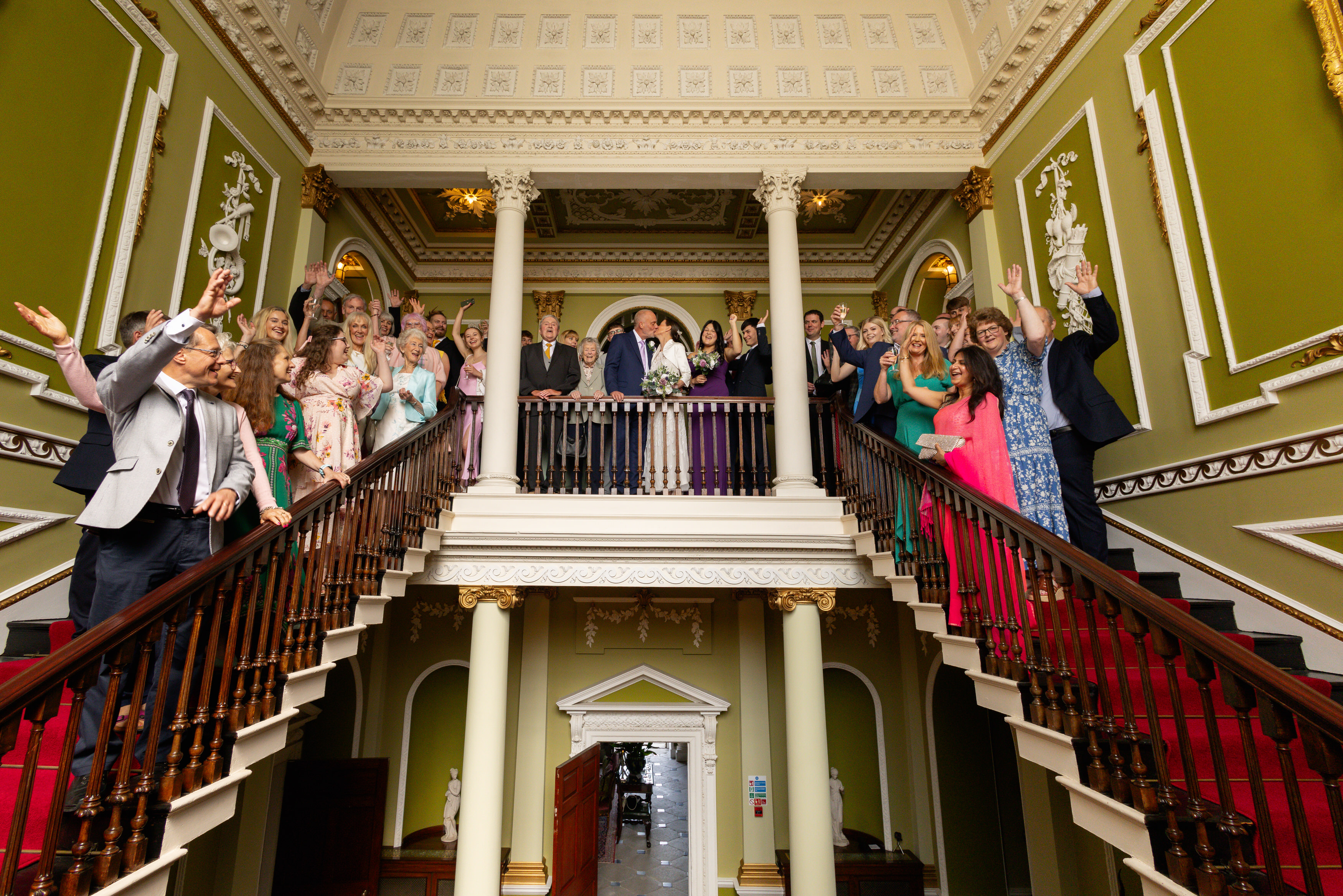 Everyone gathers on the staircase for a group wedding photo 