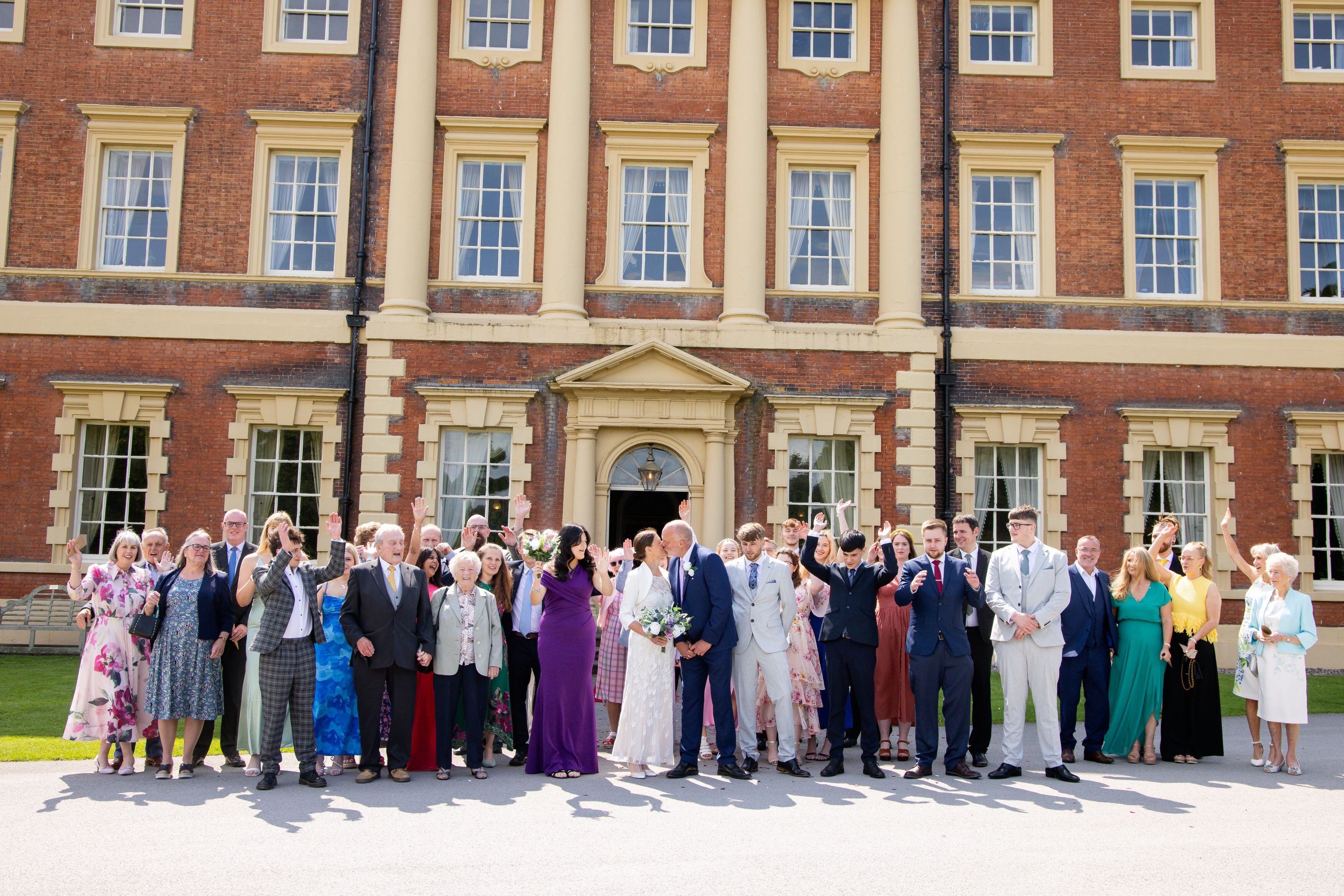 A group photo of the bridling room with all their wedding guests 